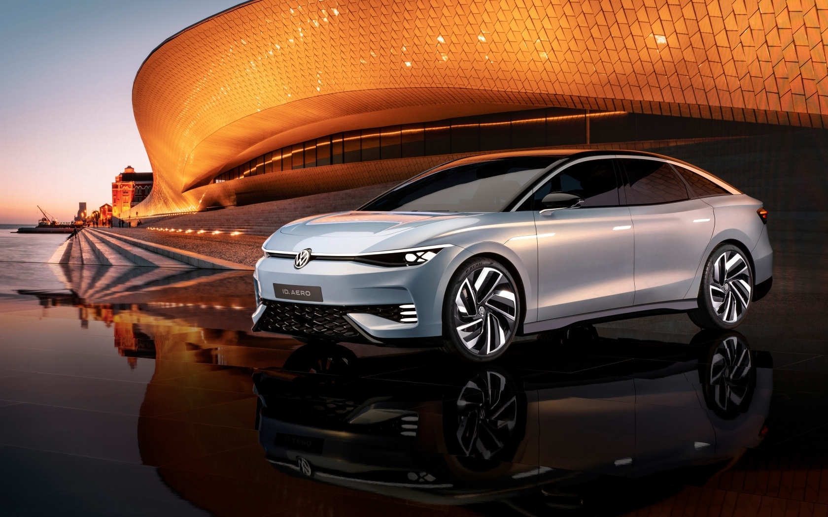 Серебристый автомобиль Volkswagen ID. AERO у здания