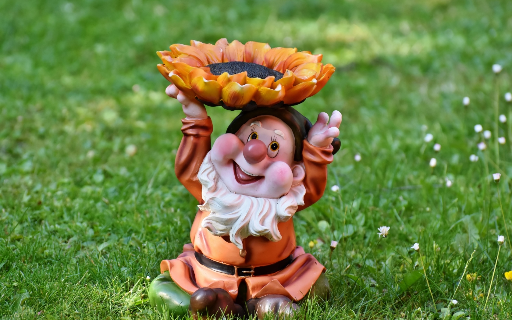 Садовая фигура гном за зеленой траве