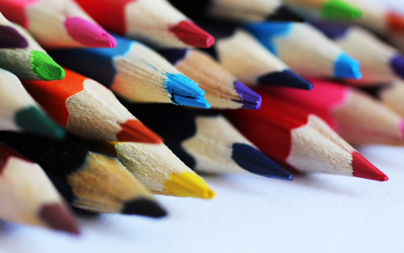 Разноцветные заточенные карандаши на столе