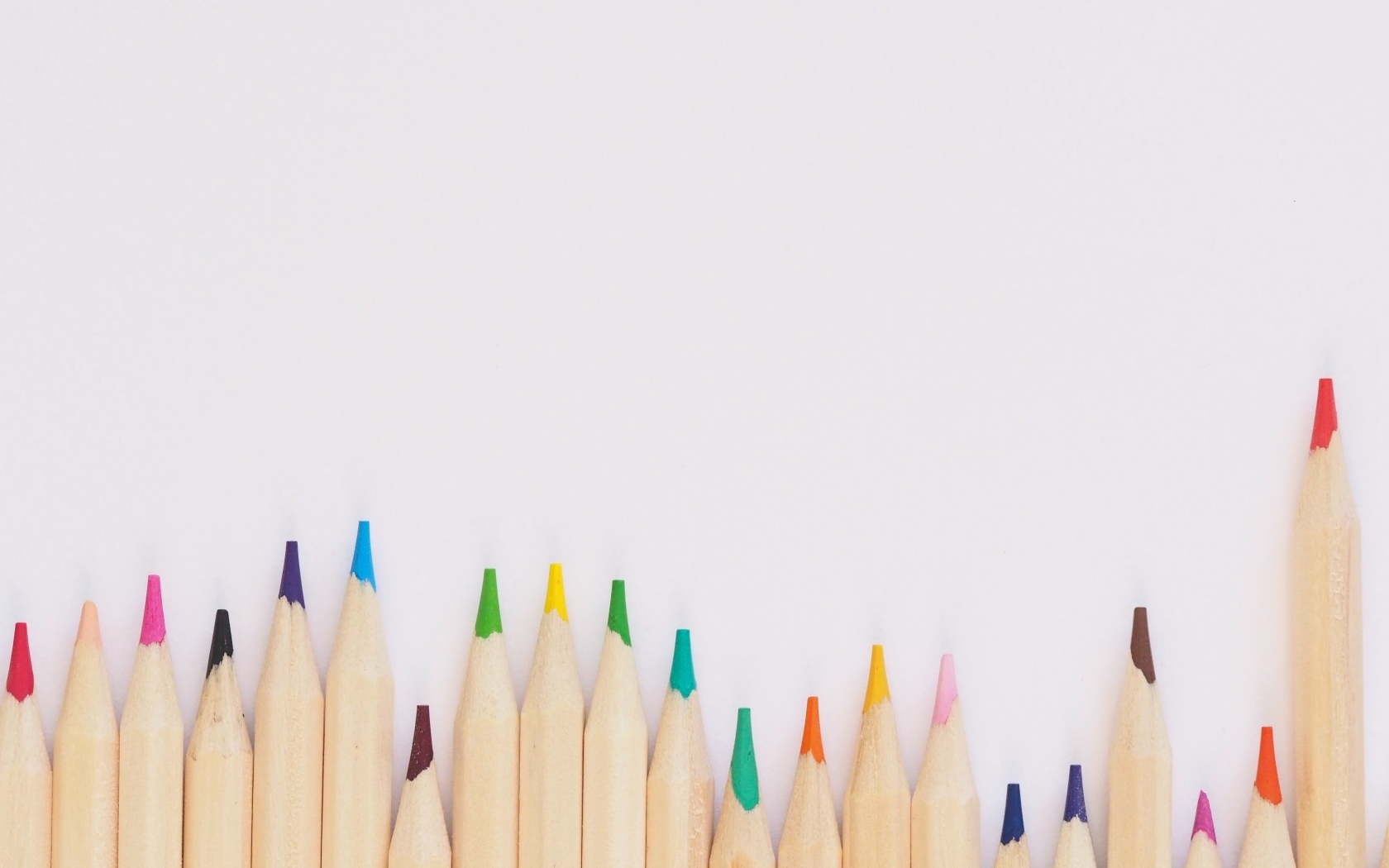 Острые разноцветные карандаши на сером фоне
