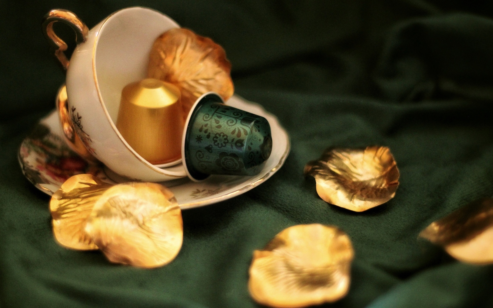 Золотые лепестки и чашка на столе