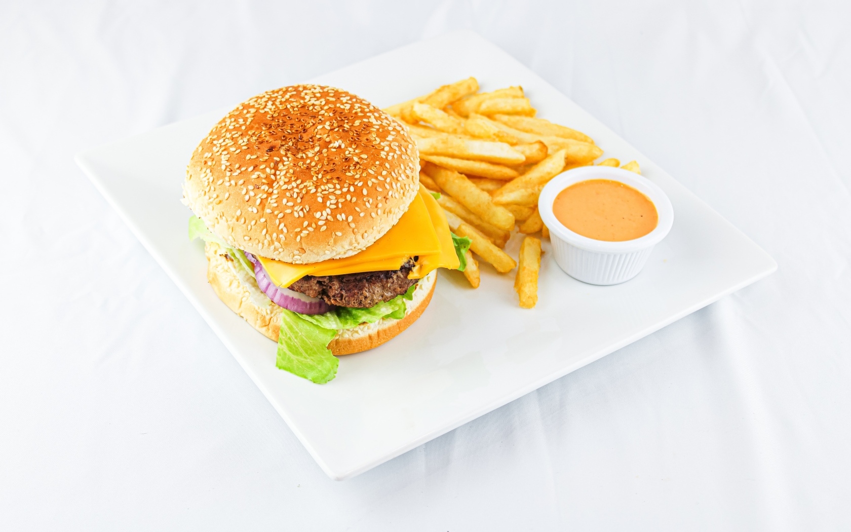 Гамбургер с картофелем фри и соусом на столе