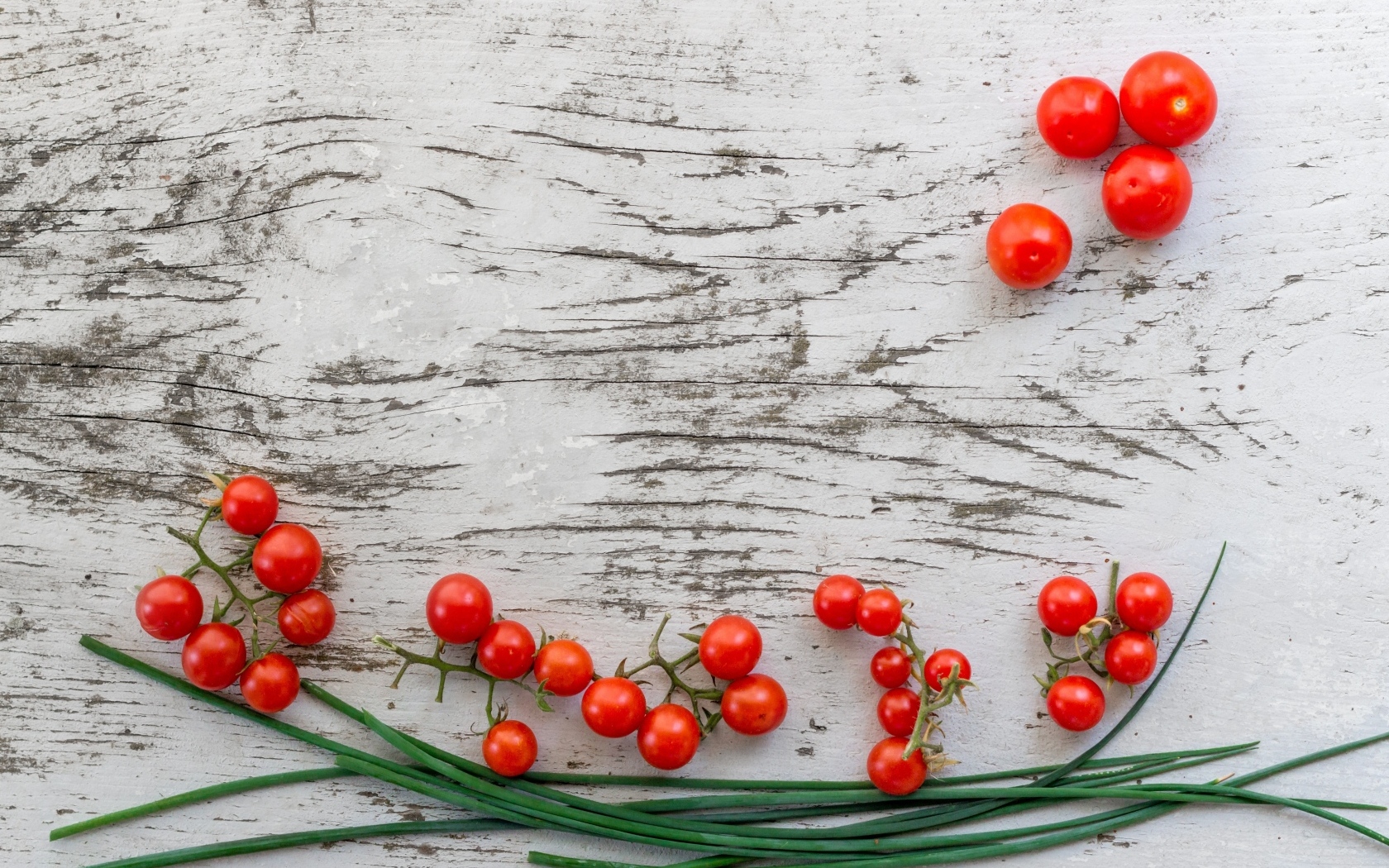 Красные помидоры с зеленым луком на деревянном столе