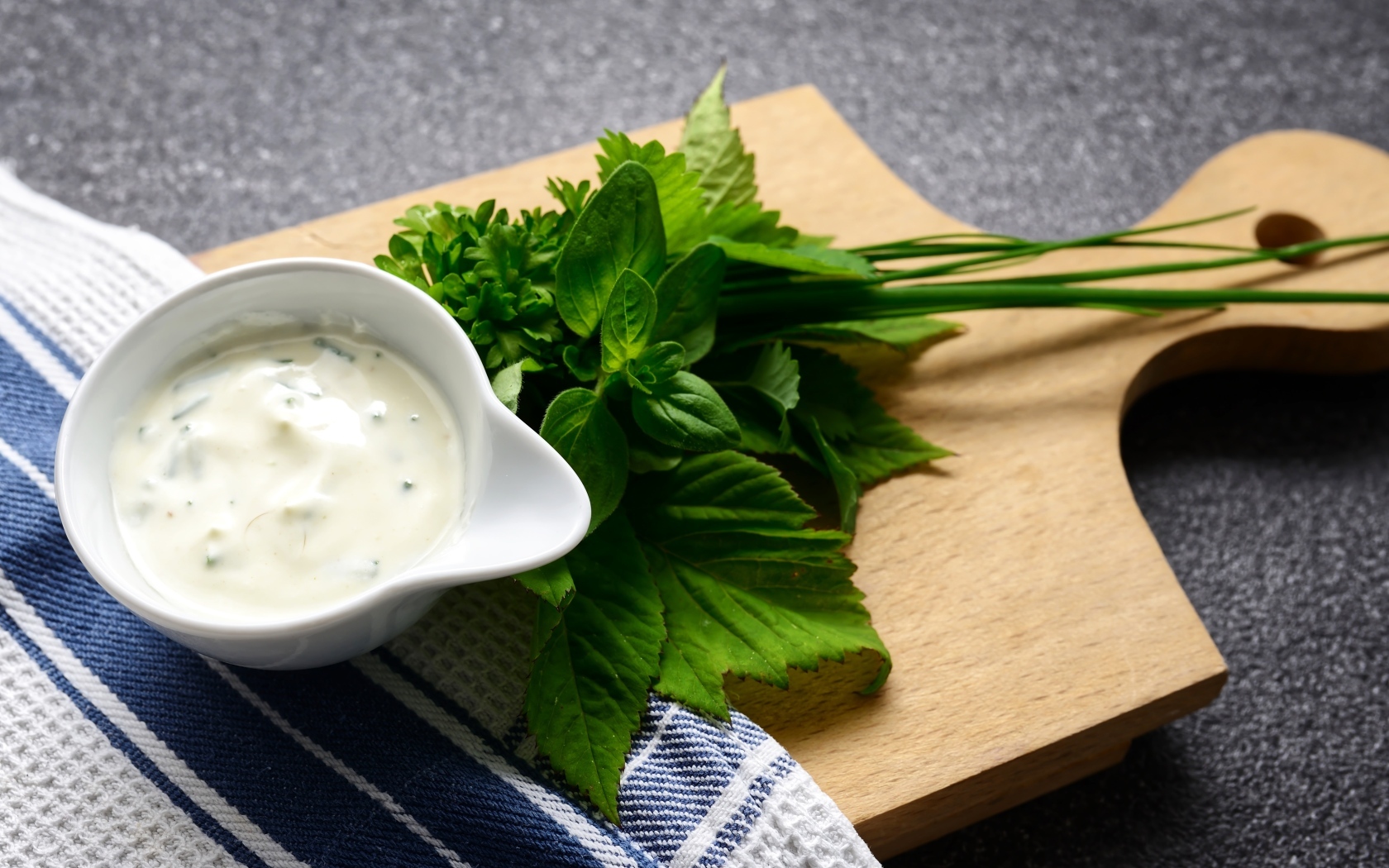 Соус с зеленью на деревянной доске 