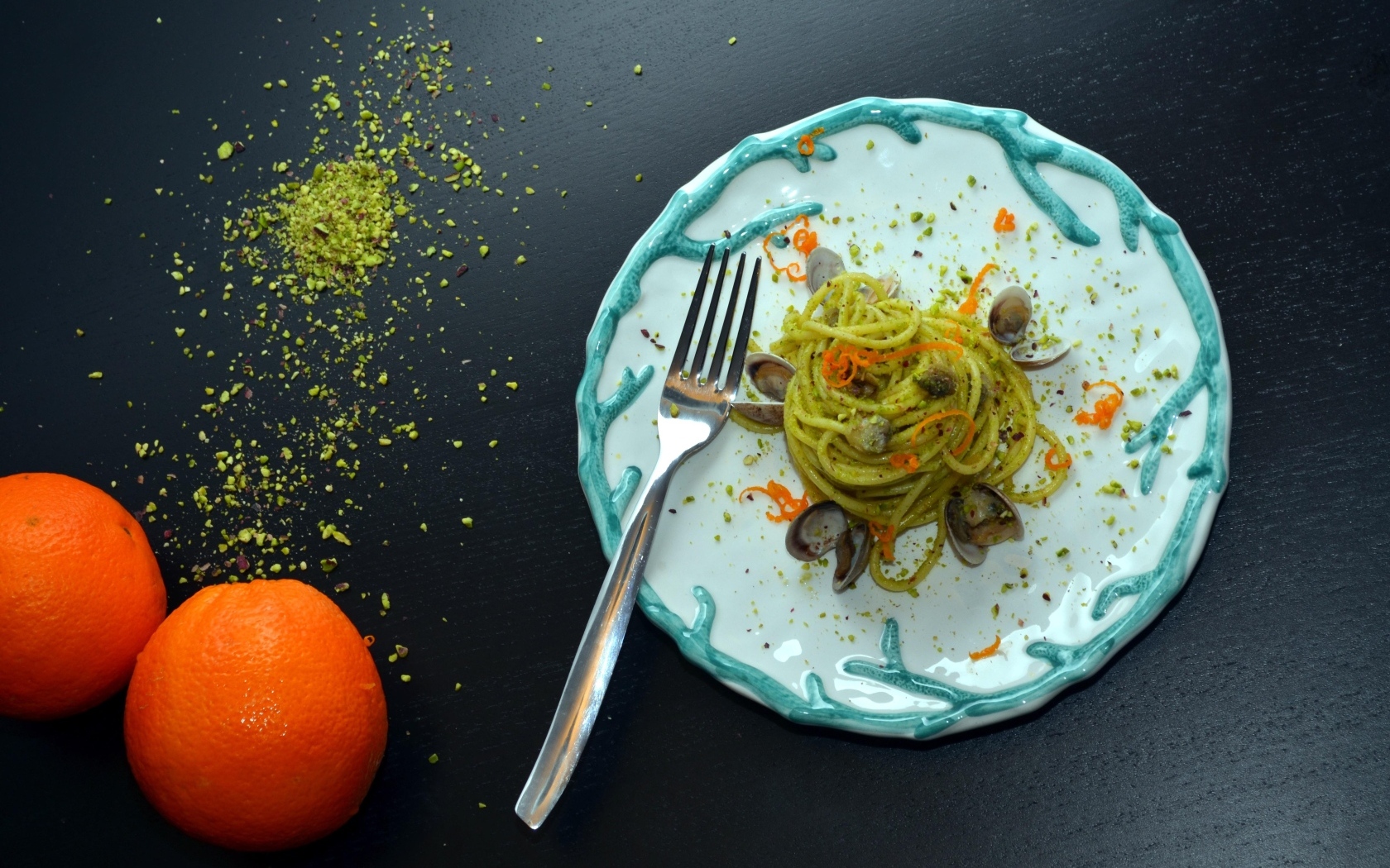 Спагетти с морепродуктами на столе с апельсинами