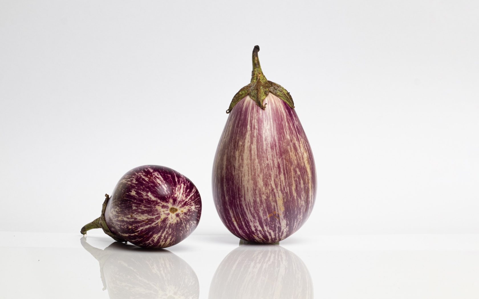 Два баклажана на сером фоне