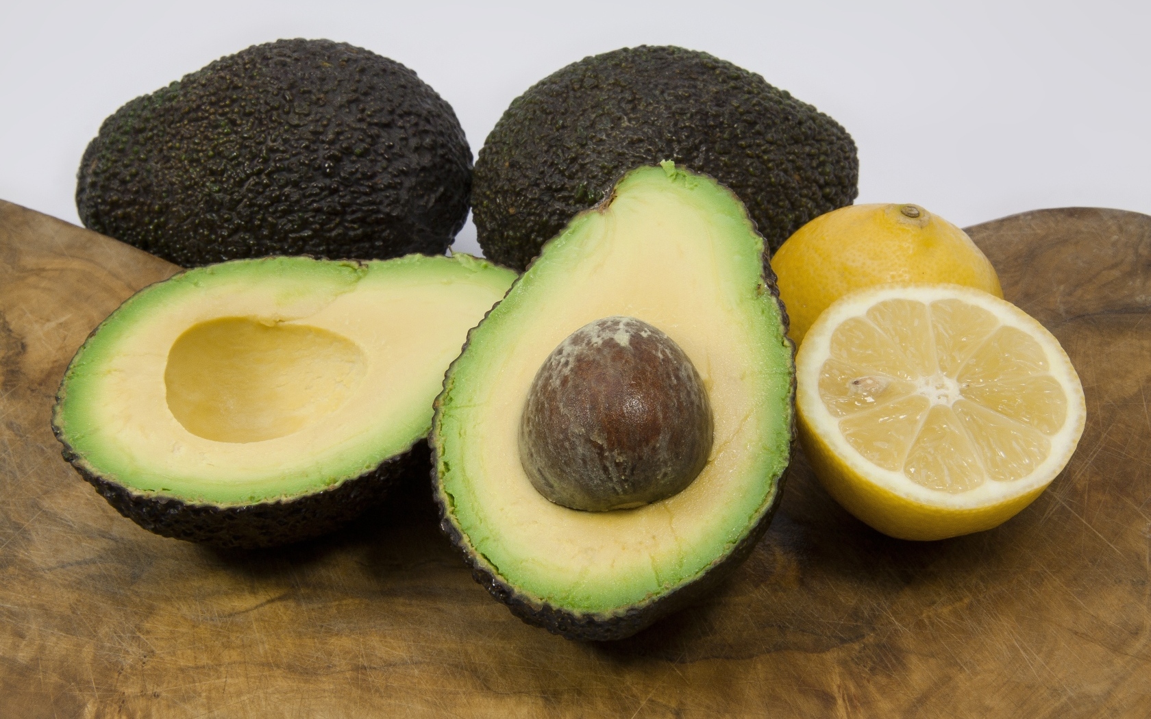 Авокадо на столе с половинками лимона