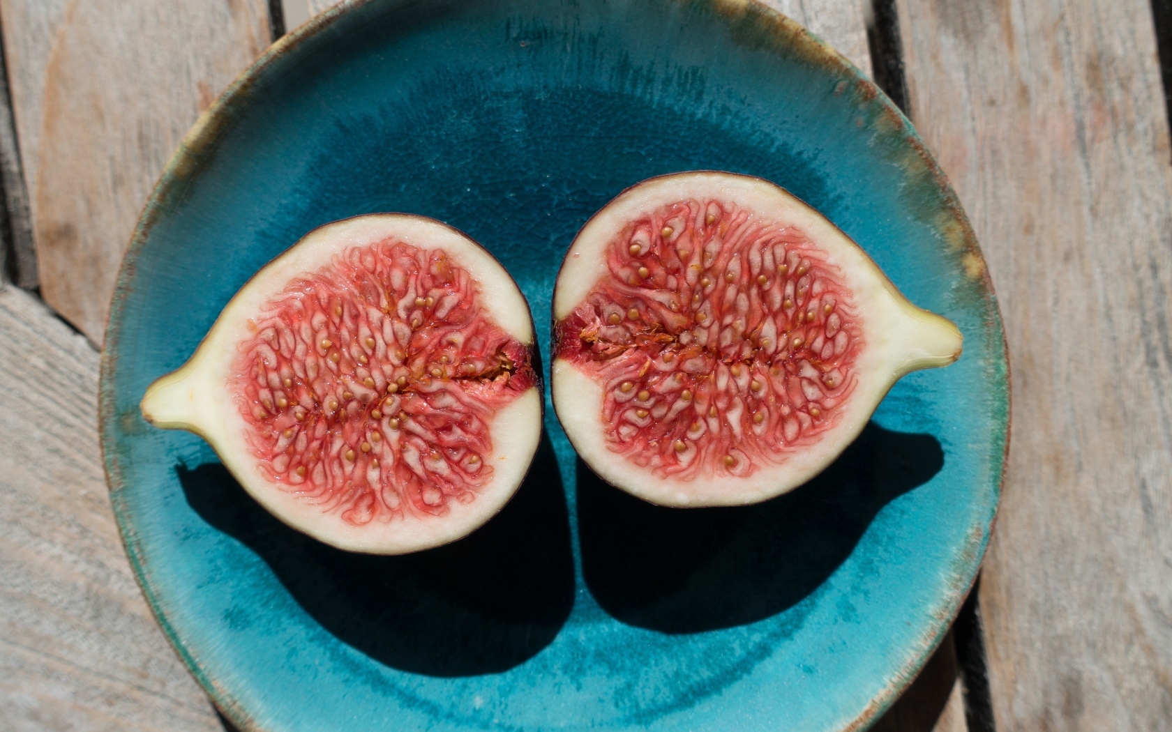Половинки инжира на голубой тарелке