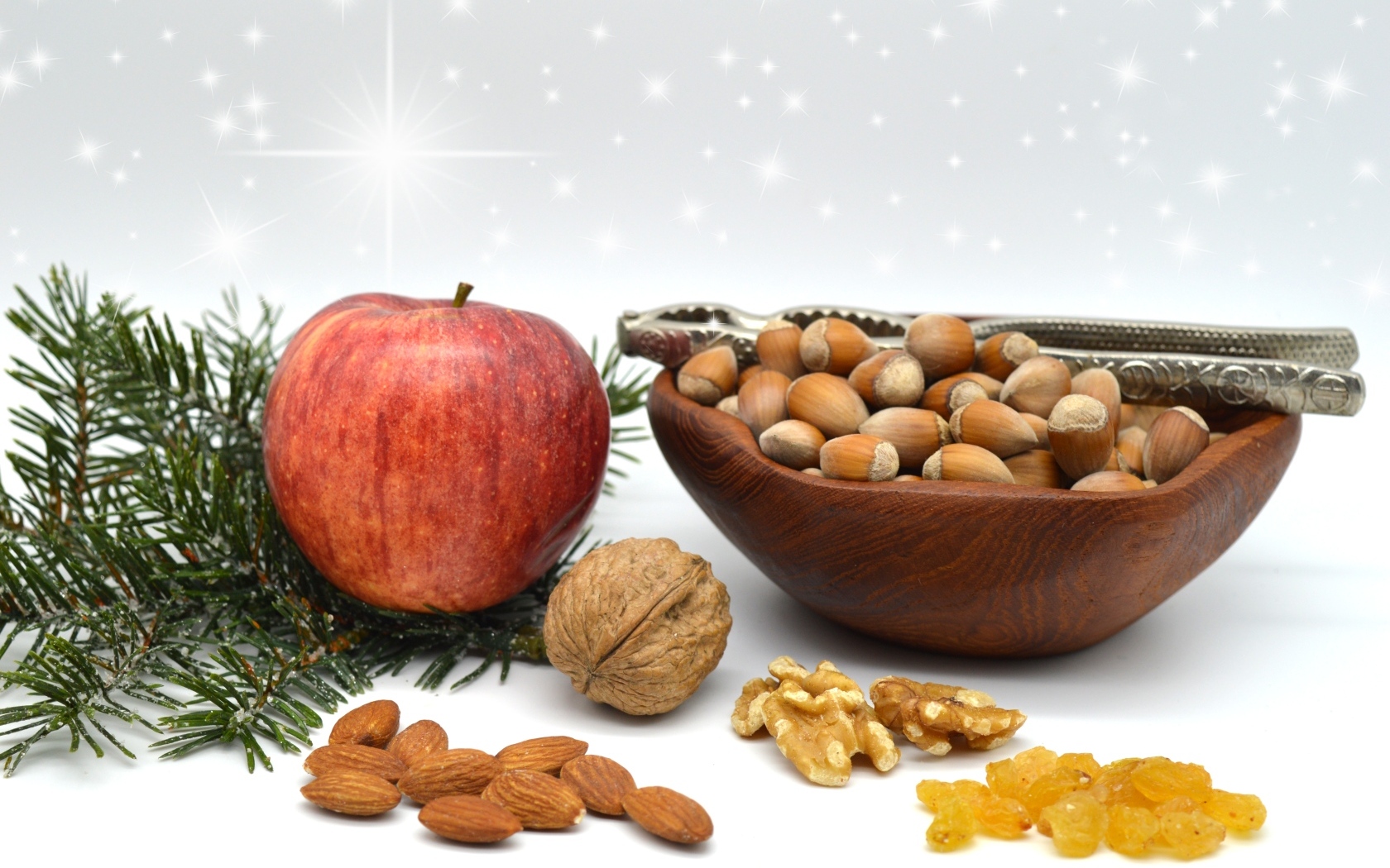 Орехи с яблоком и еловой веткой на столе