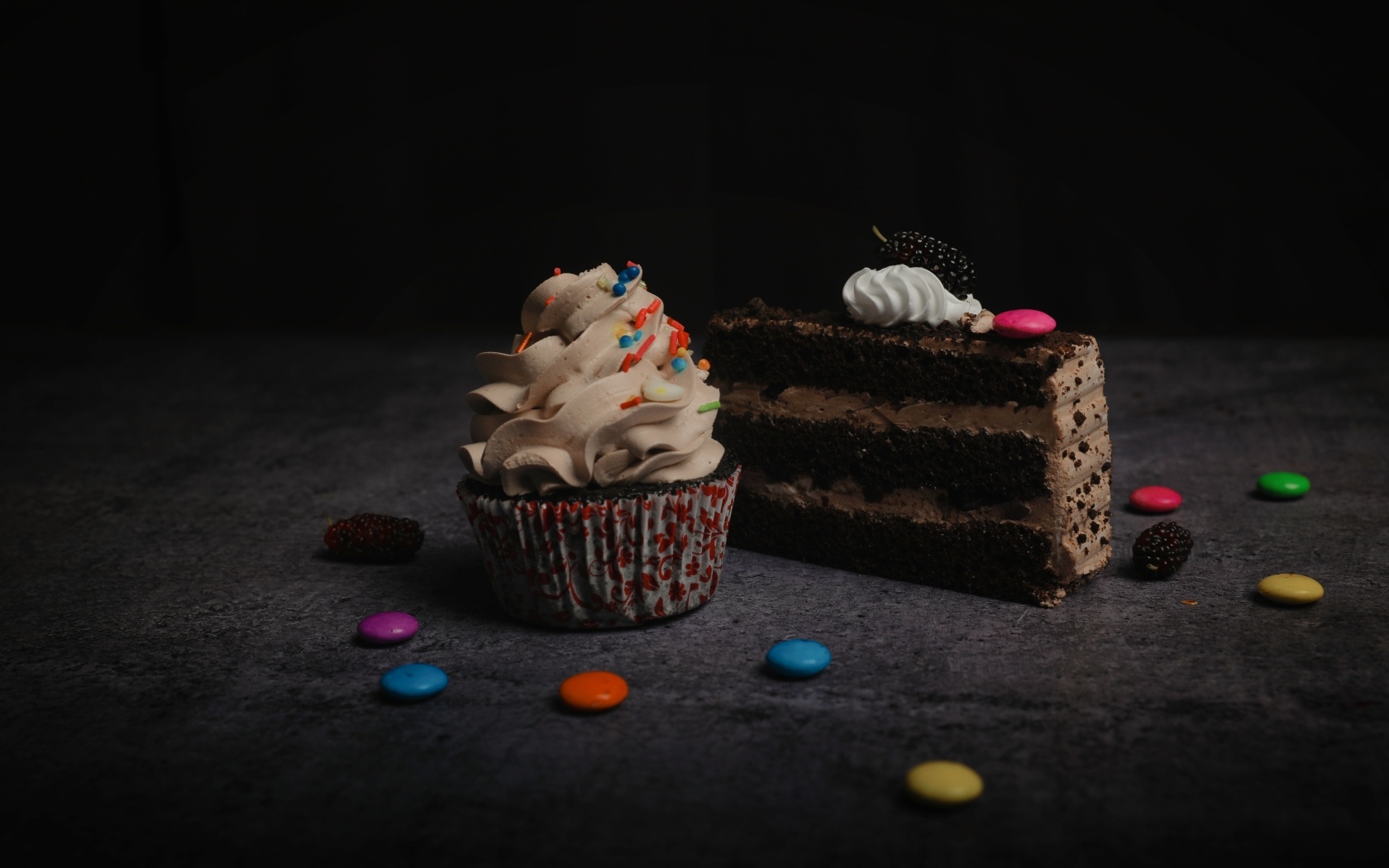 Кусок торта и кекс с кремом на столе