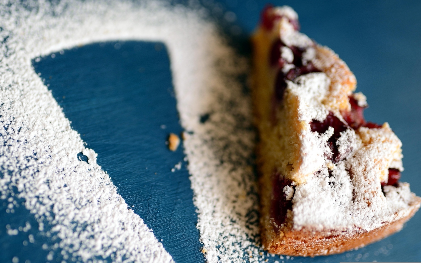 Кусок пирога с ягодами на столе с сахарной пудрой