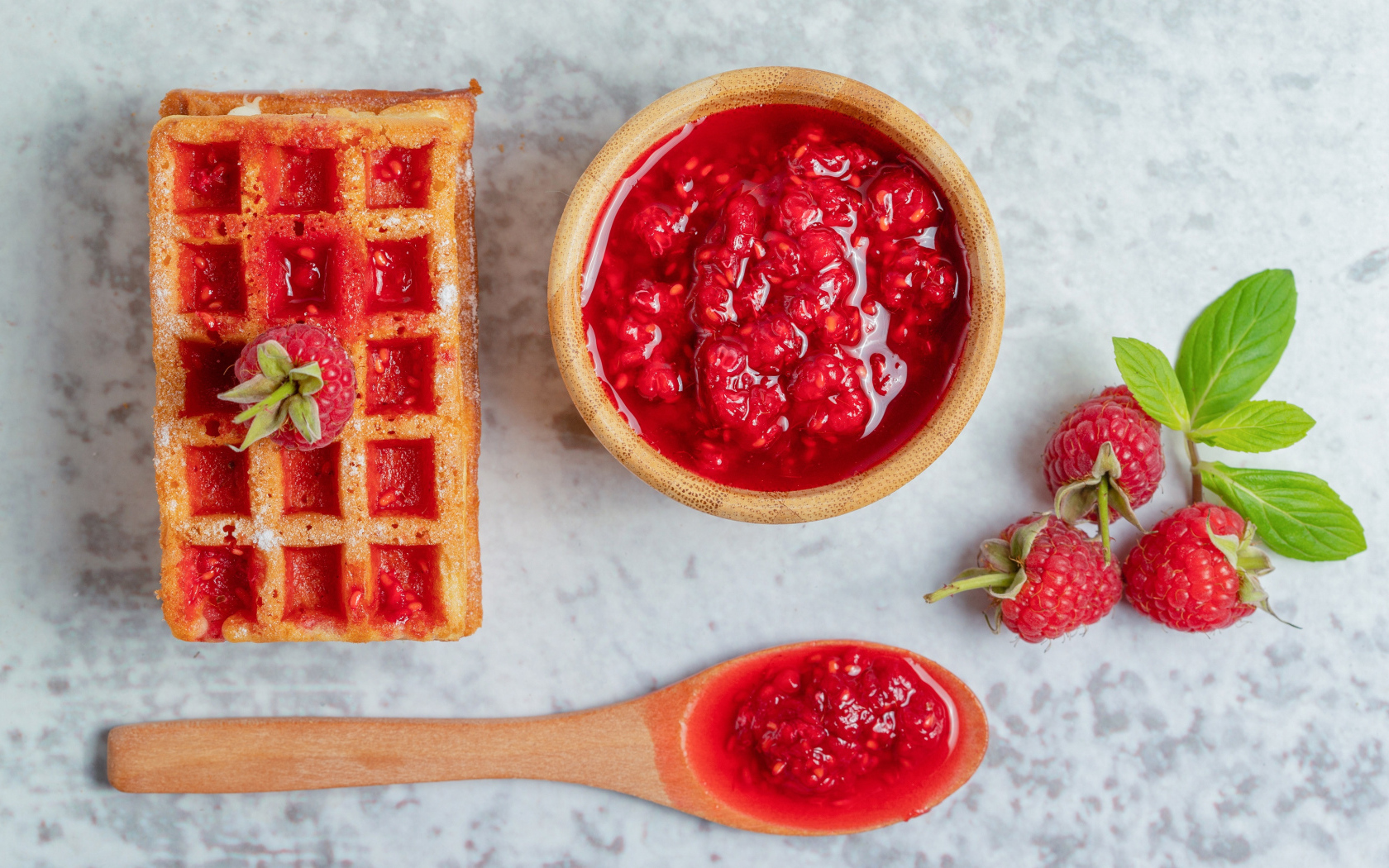 Сладкие вафли с малиновым вареньем и ягодами на столе