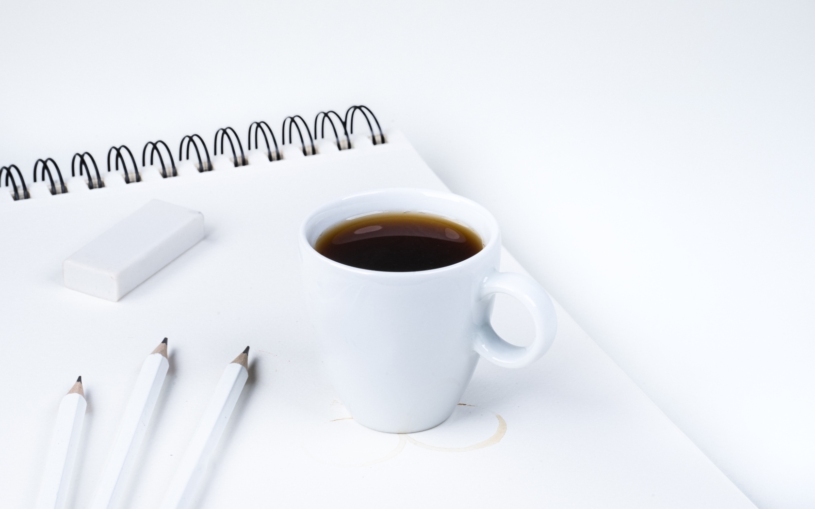 Чашка ароматного кофе с блокнотом на столе