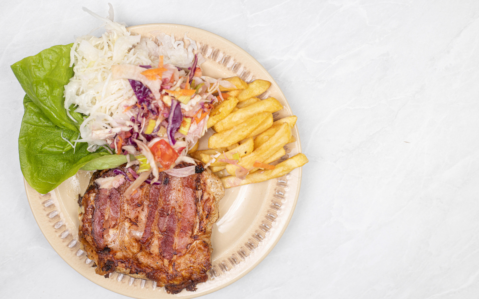 Meat on a plate with french fries and salad