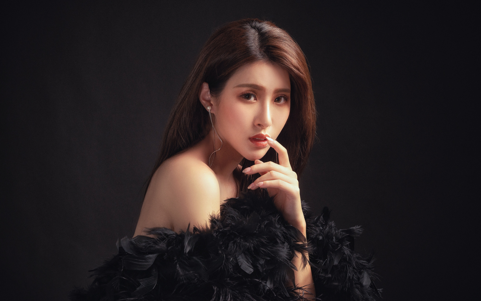 Девушка азиатка в боа на черном фоне