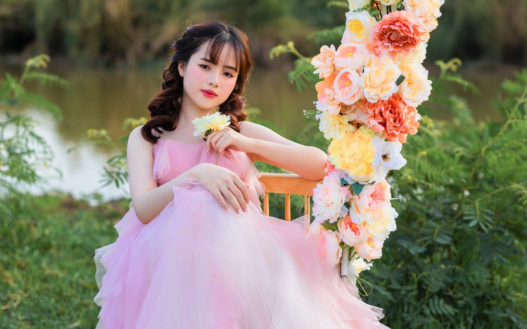 Красивая девушка азиатка в розовом платье с цветами