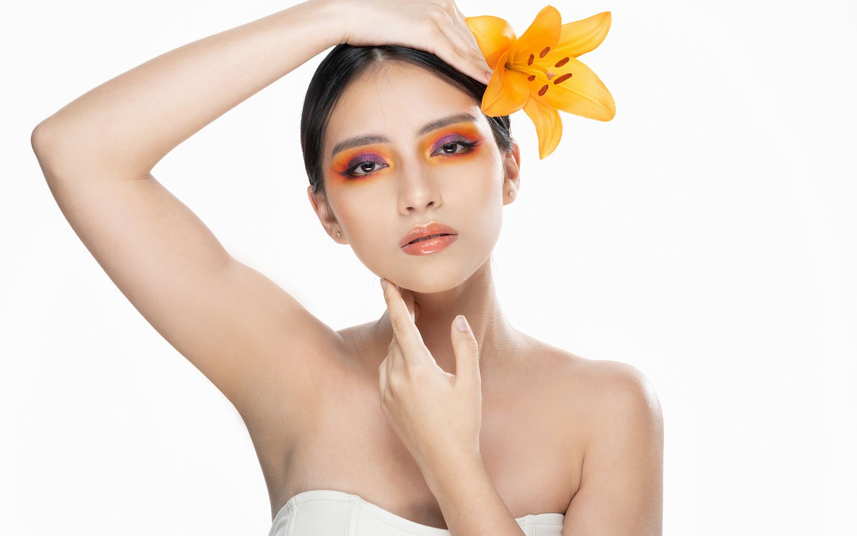 Красивая девушка с цветком лилии в волосах на белом фоне