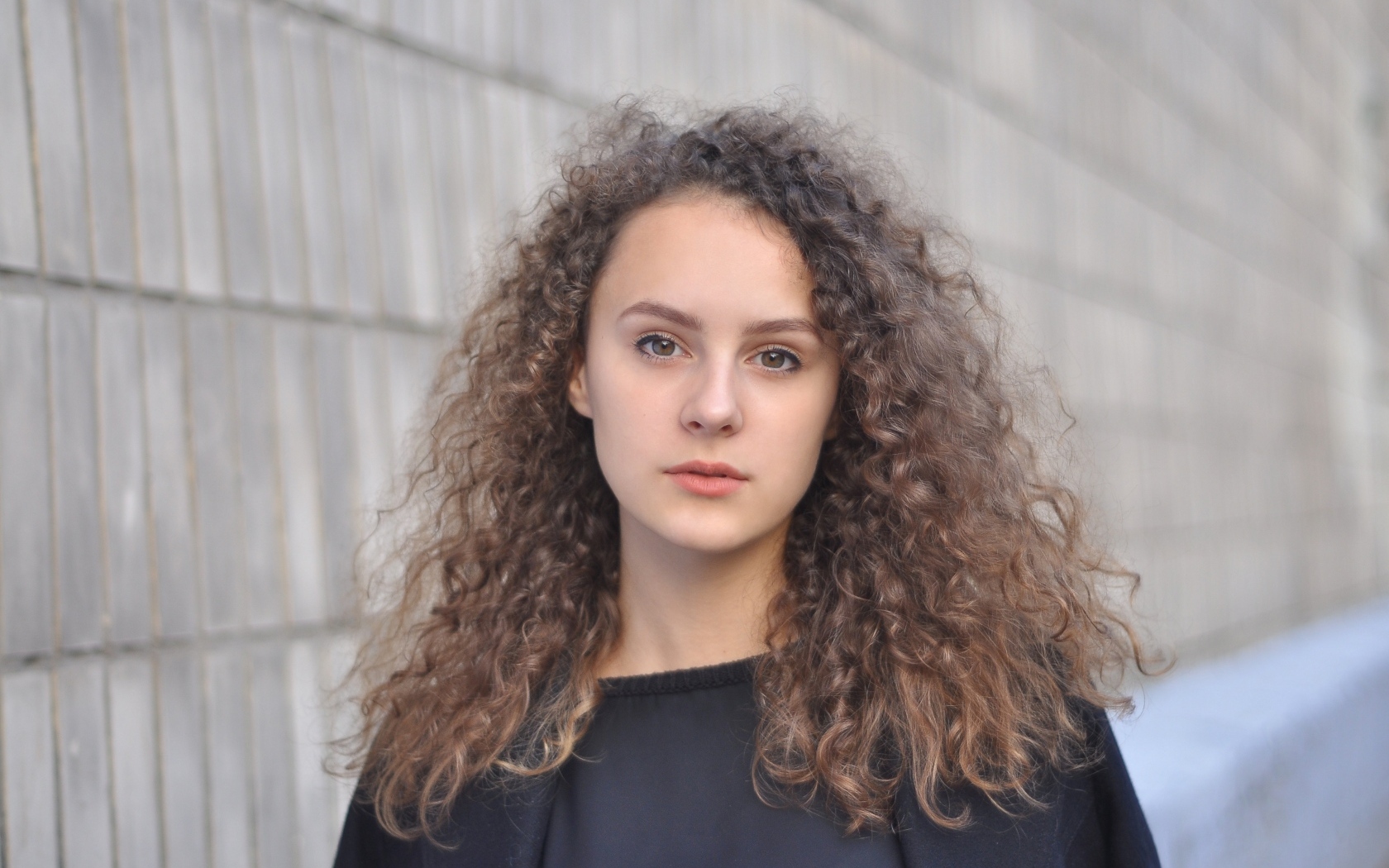 Кудрявые волосы красивой кареглазой девушки 