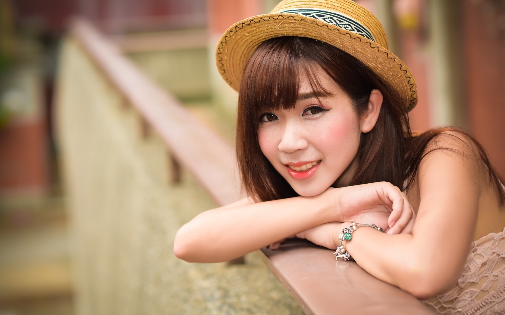 Милая улыбка азиатки в соломенной шляпе 
