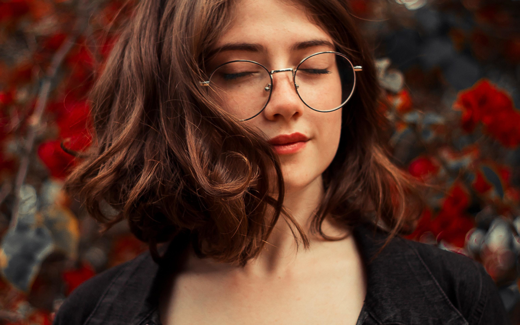 Мечтательная девушка в очках с закрытыми глазами