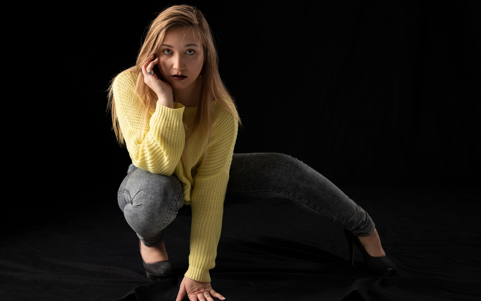 Девушка в желтом свитере на черном фоне