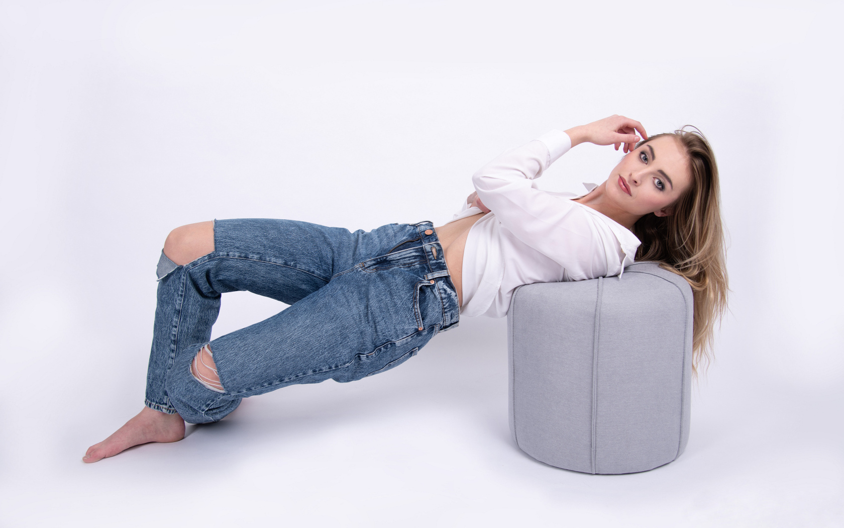 Молодая девушка в джинсах на белом фоне