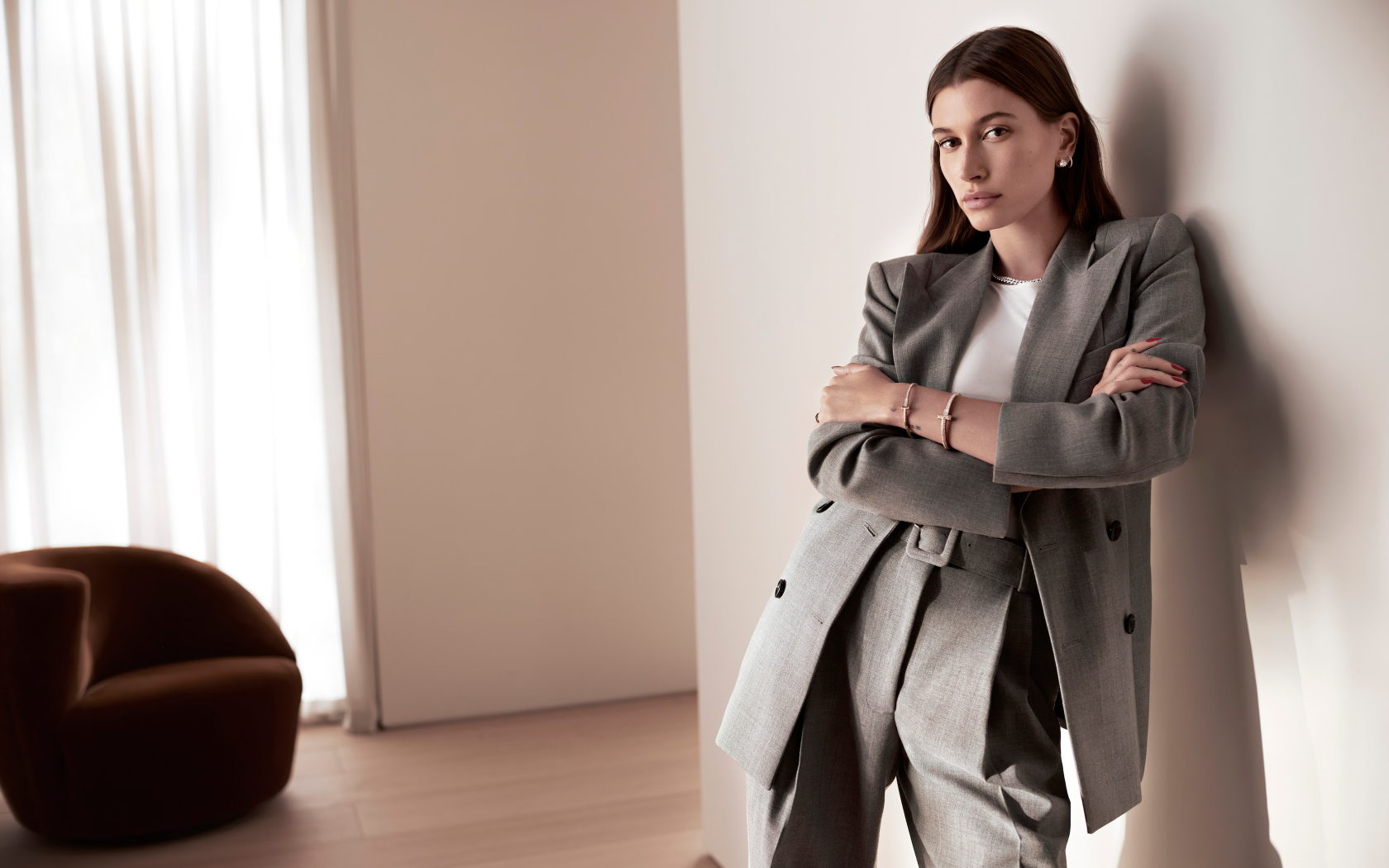 Модель Хейли Болдуин в костюме у стены