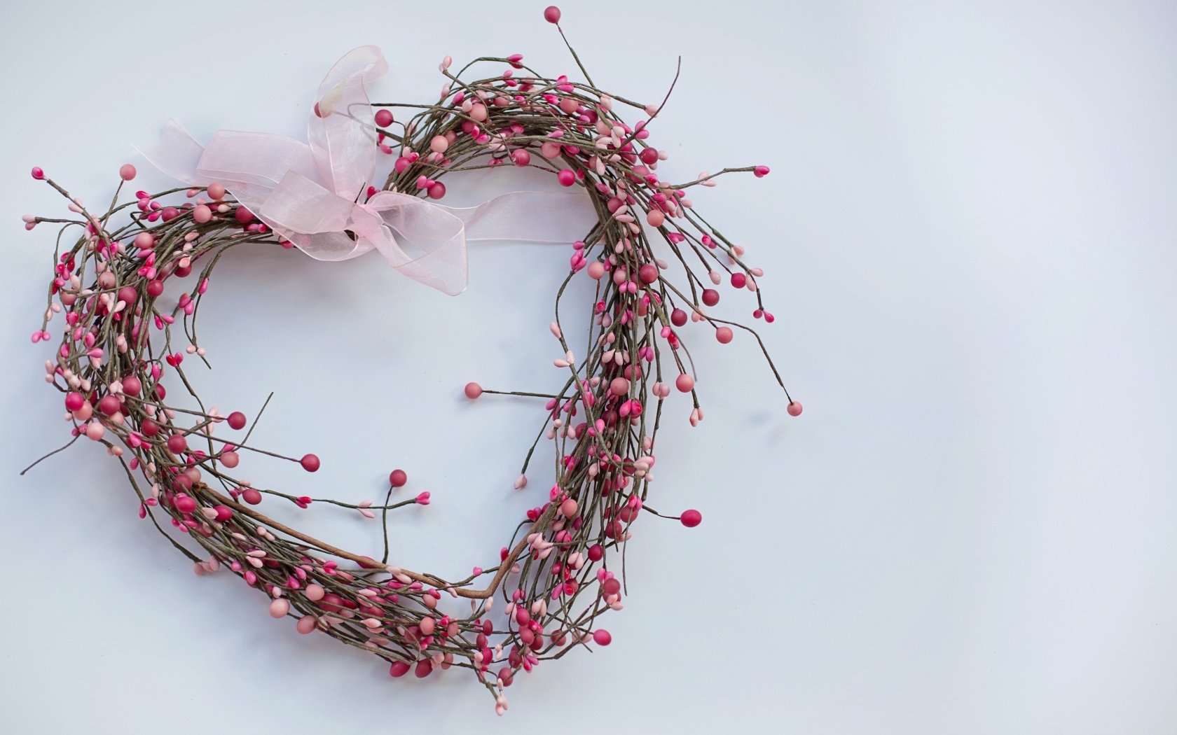 Сердце из веток с лентой на сером фоне
