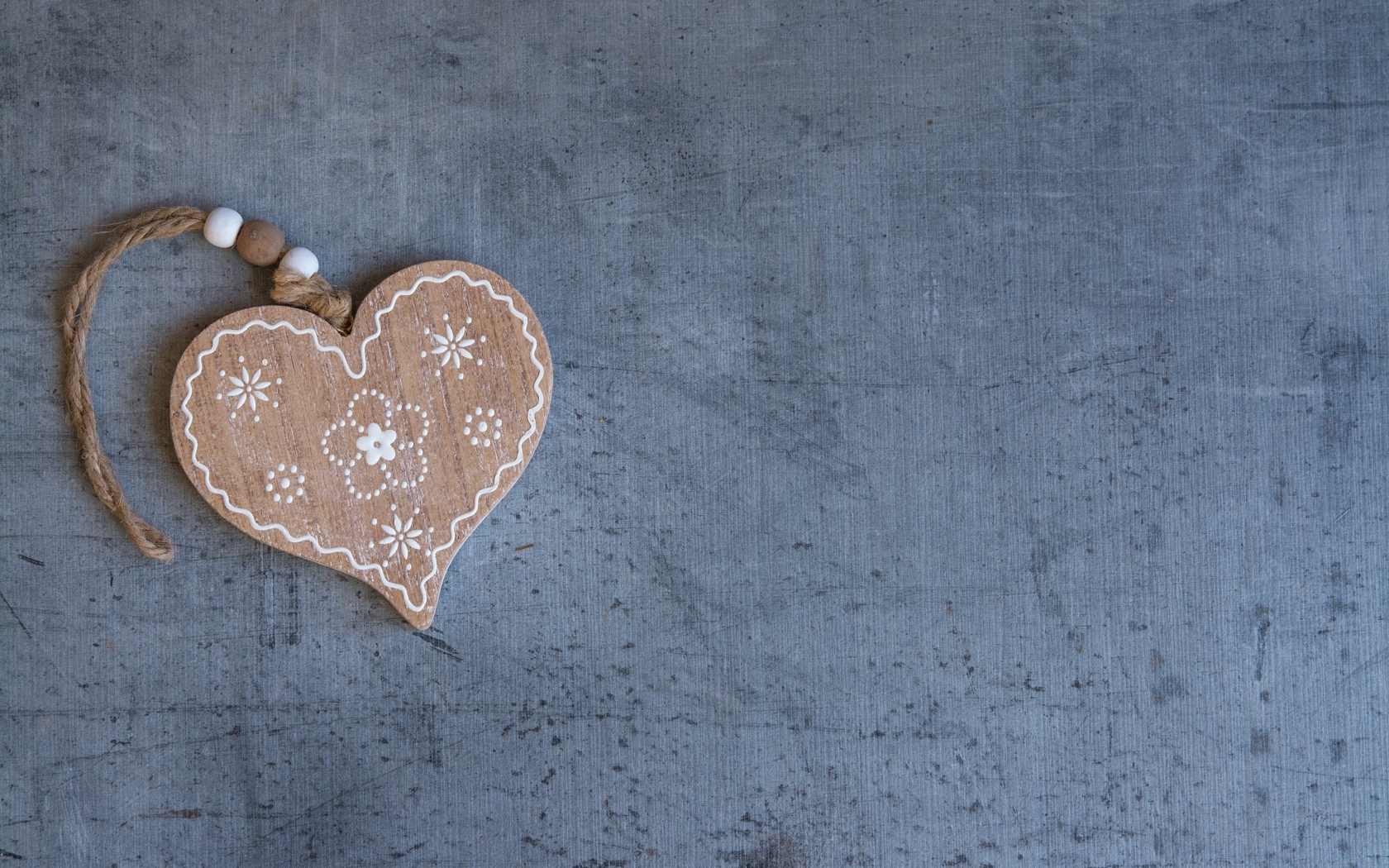 Деревянное сердце на нитке на сером фоне