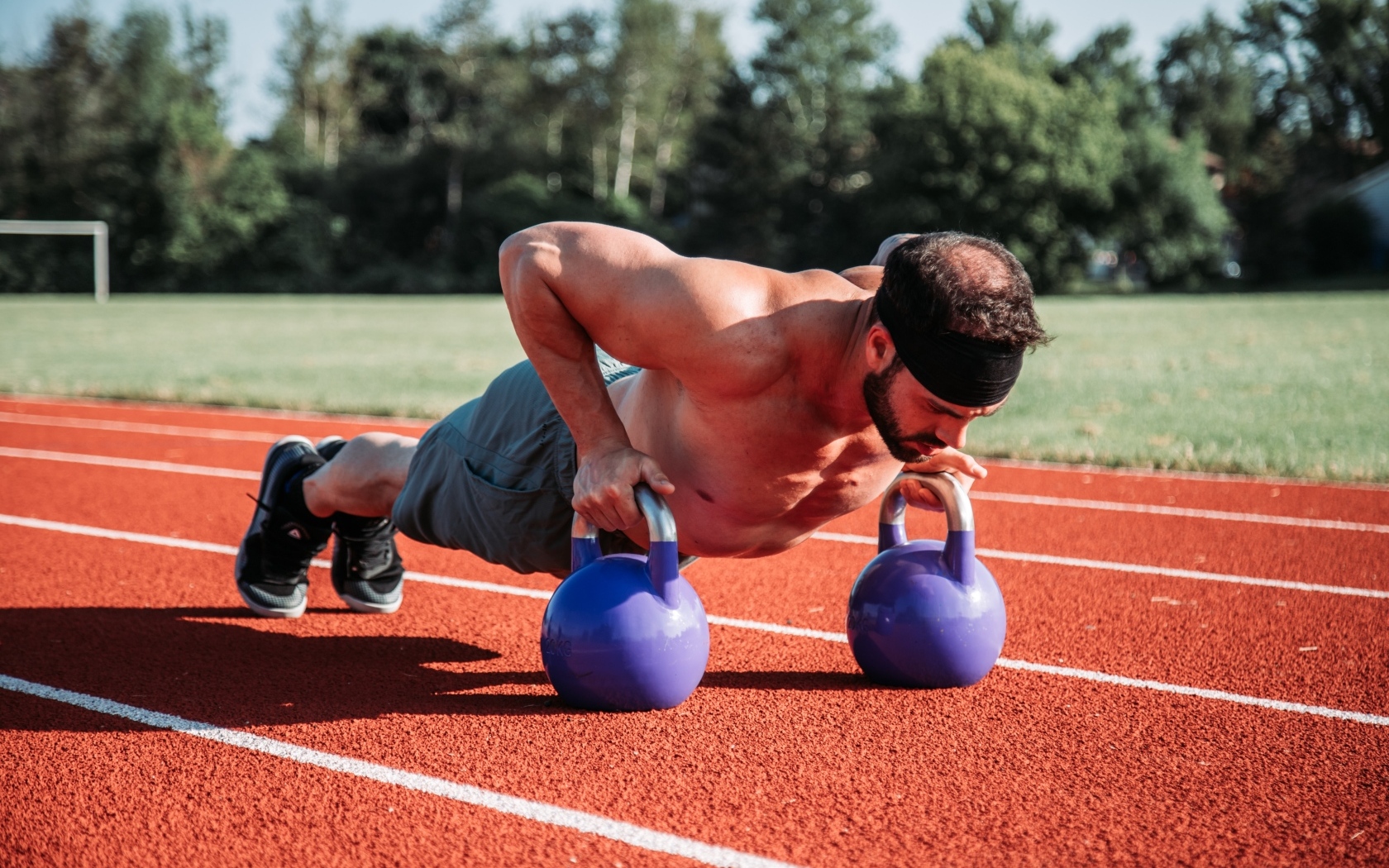 Мужчина спортсмен занимается с гирями