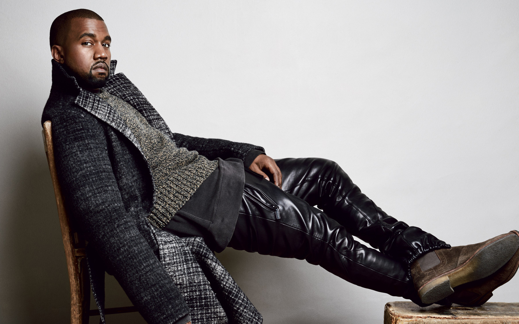 Рэпер Канье Уэст сидит на стуле