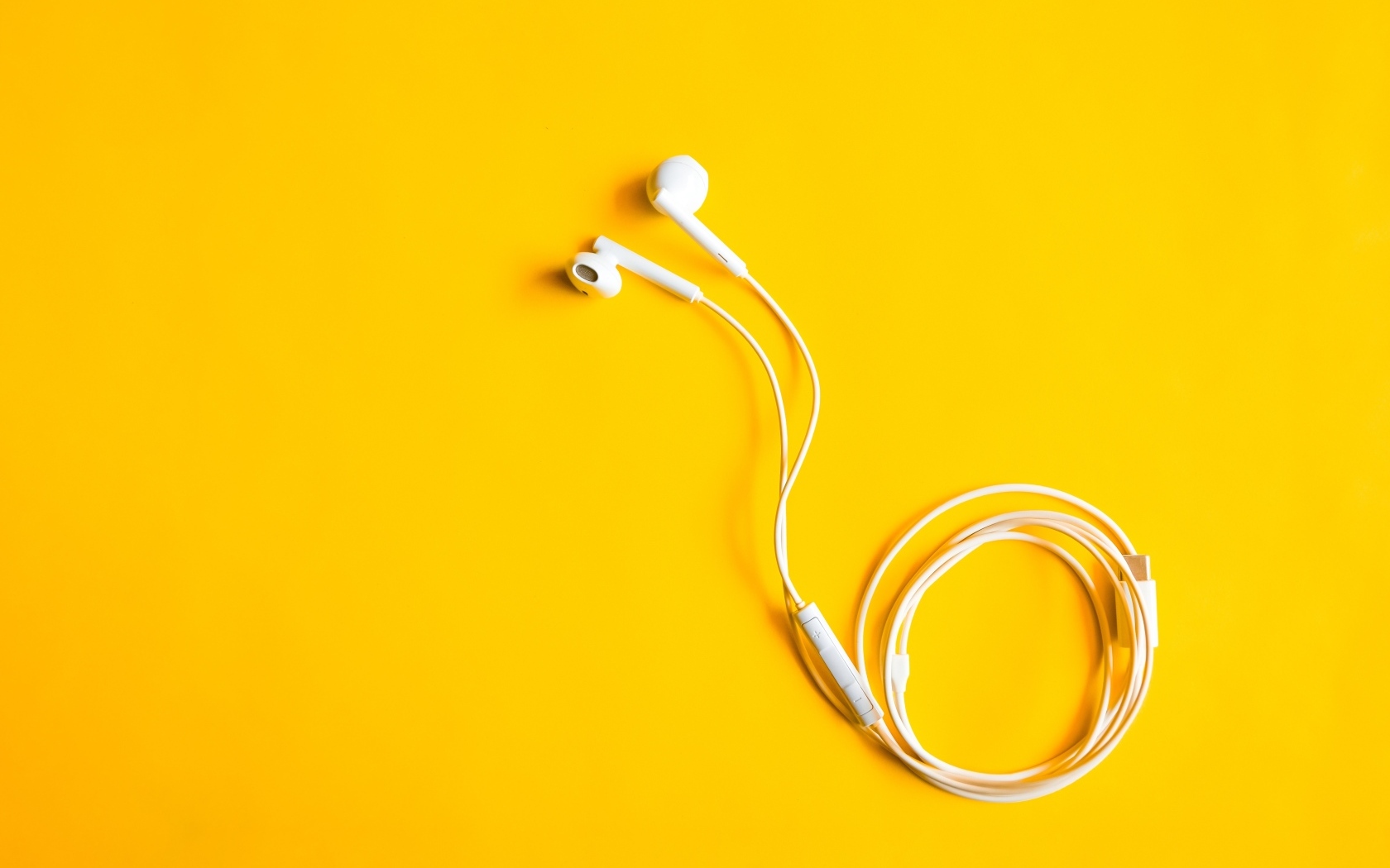 Белые наушники на желтом фоне