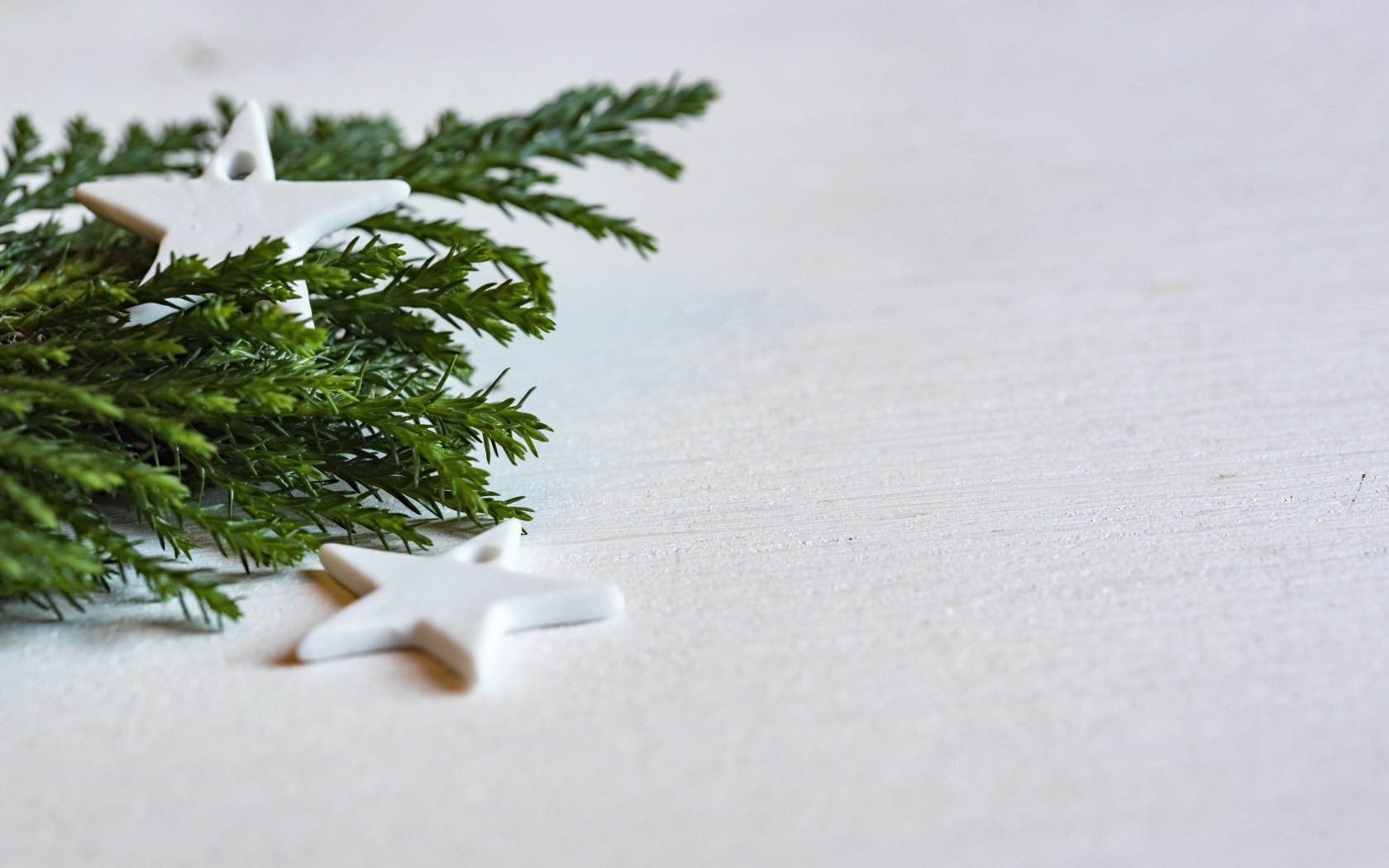 Звезды и ветка ели на белой поверхности 