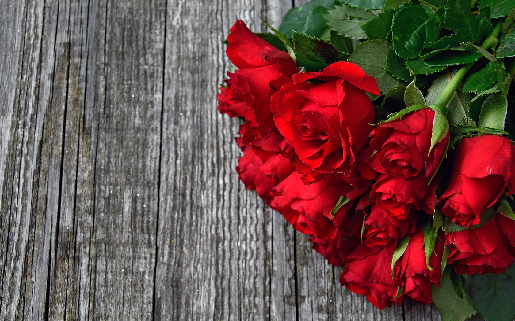 Букет красных роз на деревянном столе