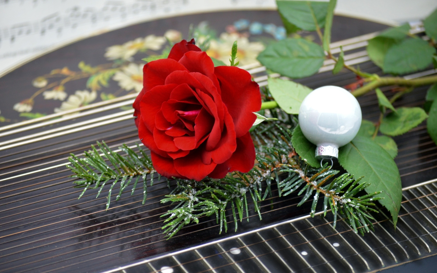Красная роза с шариком и еловой веткой
