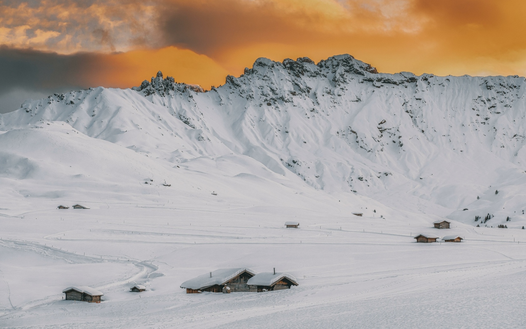 Красивая заснеженная гора под оранжевым небом