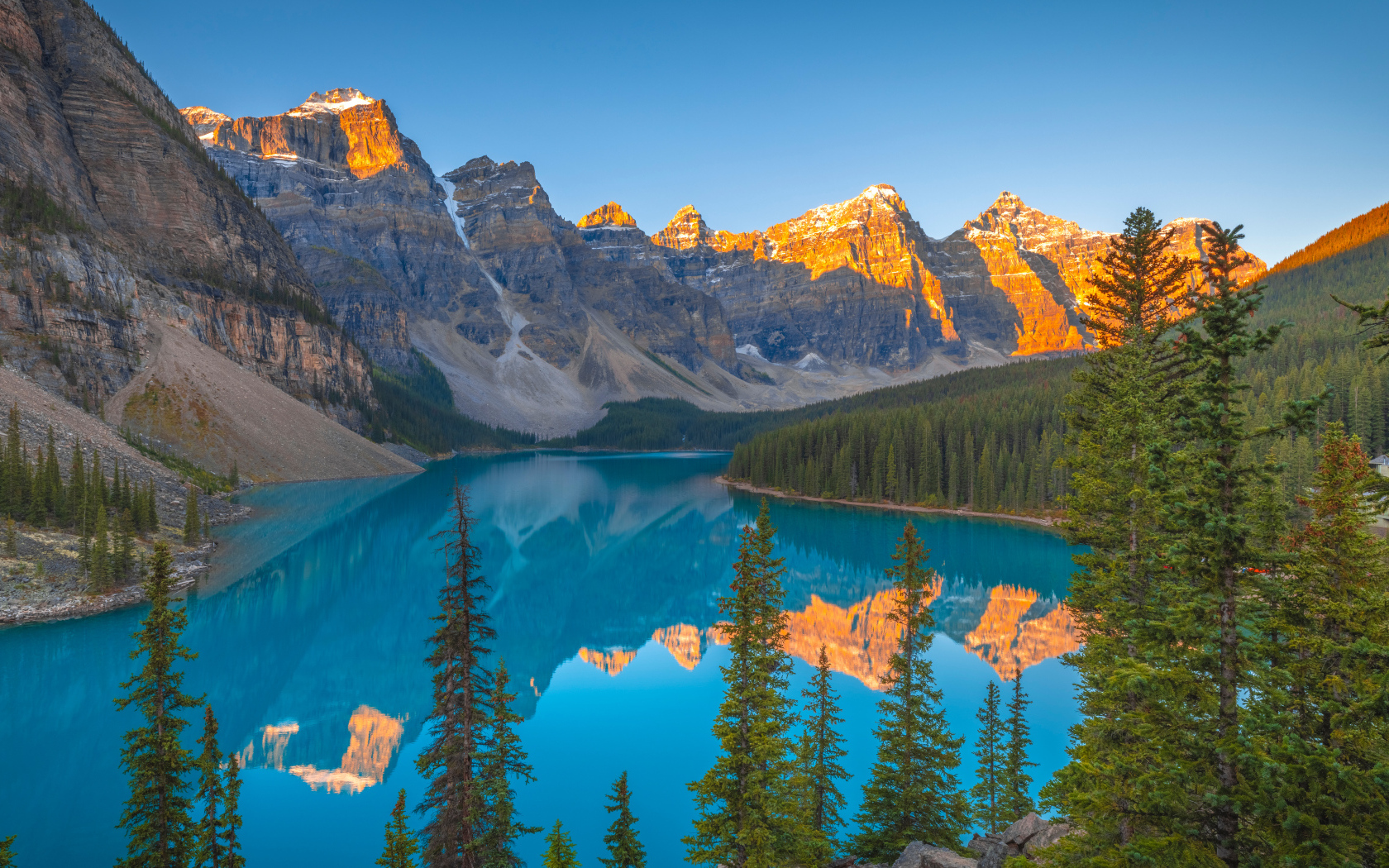 Солнце над вершинами гор у голубого озера