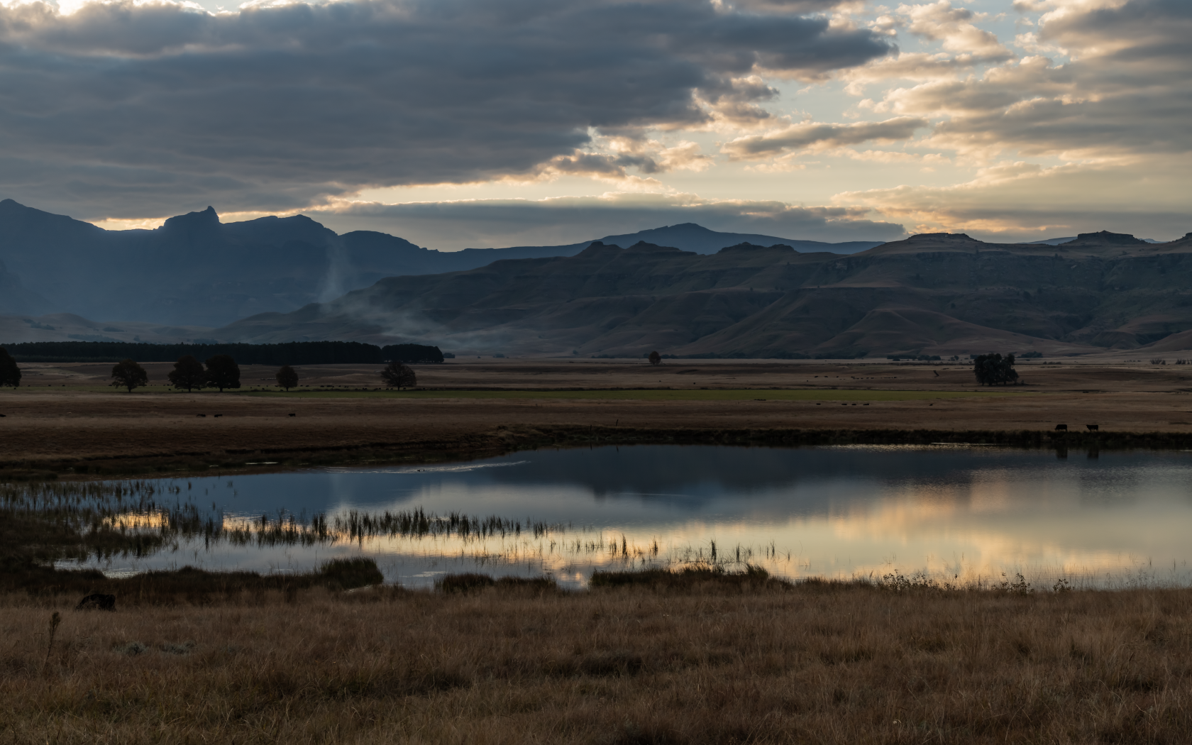 Грозовые облака отражаются в воде озера в горах 
