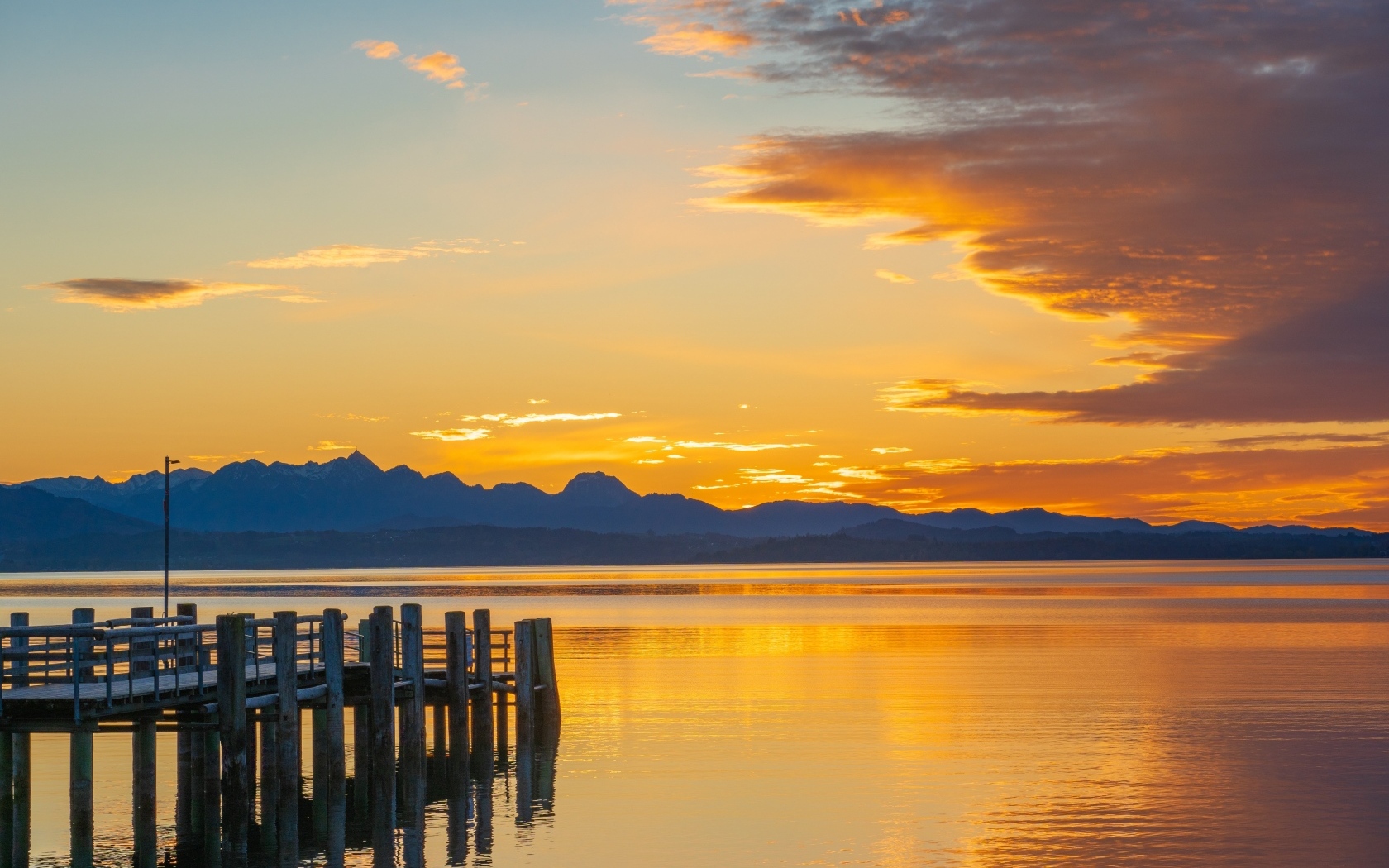 Красивый закат в небе над тихой водой озера