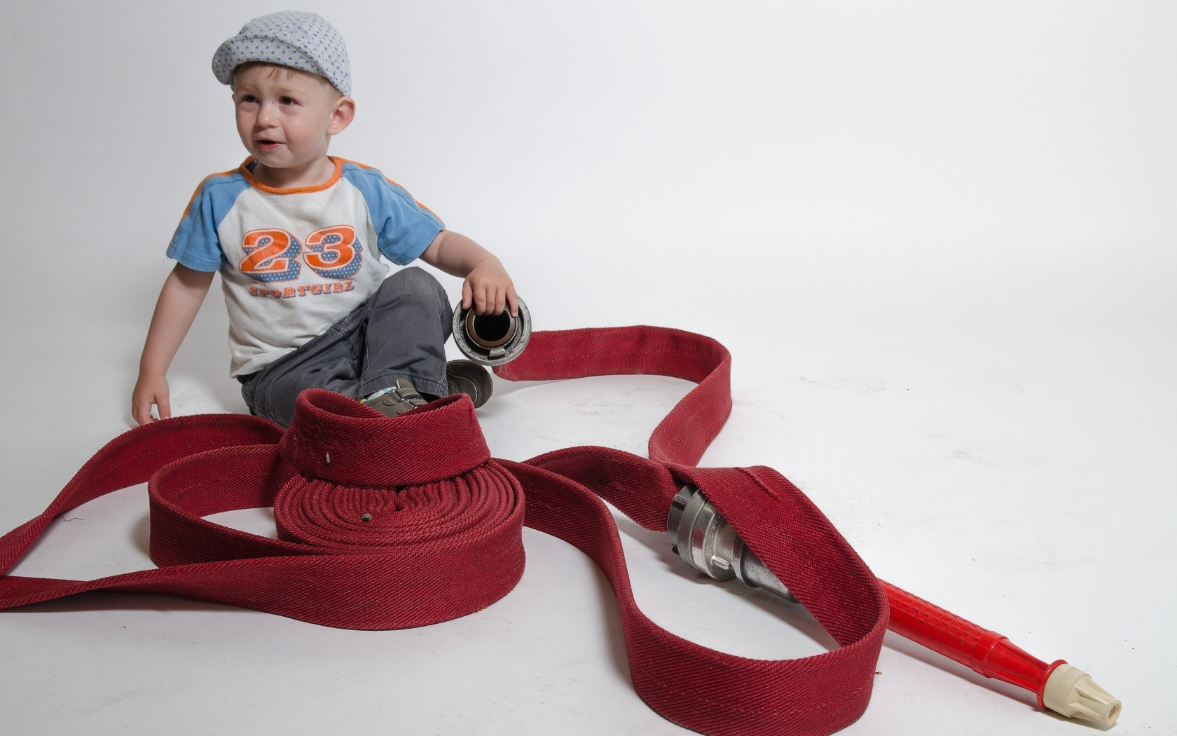 Мальчик с красным пожарным шлангом