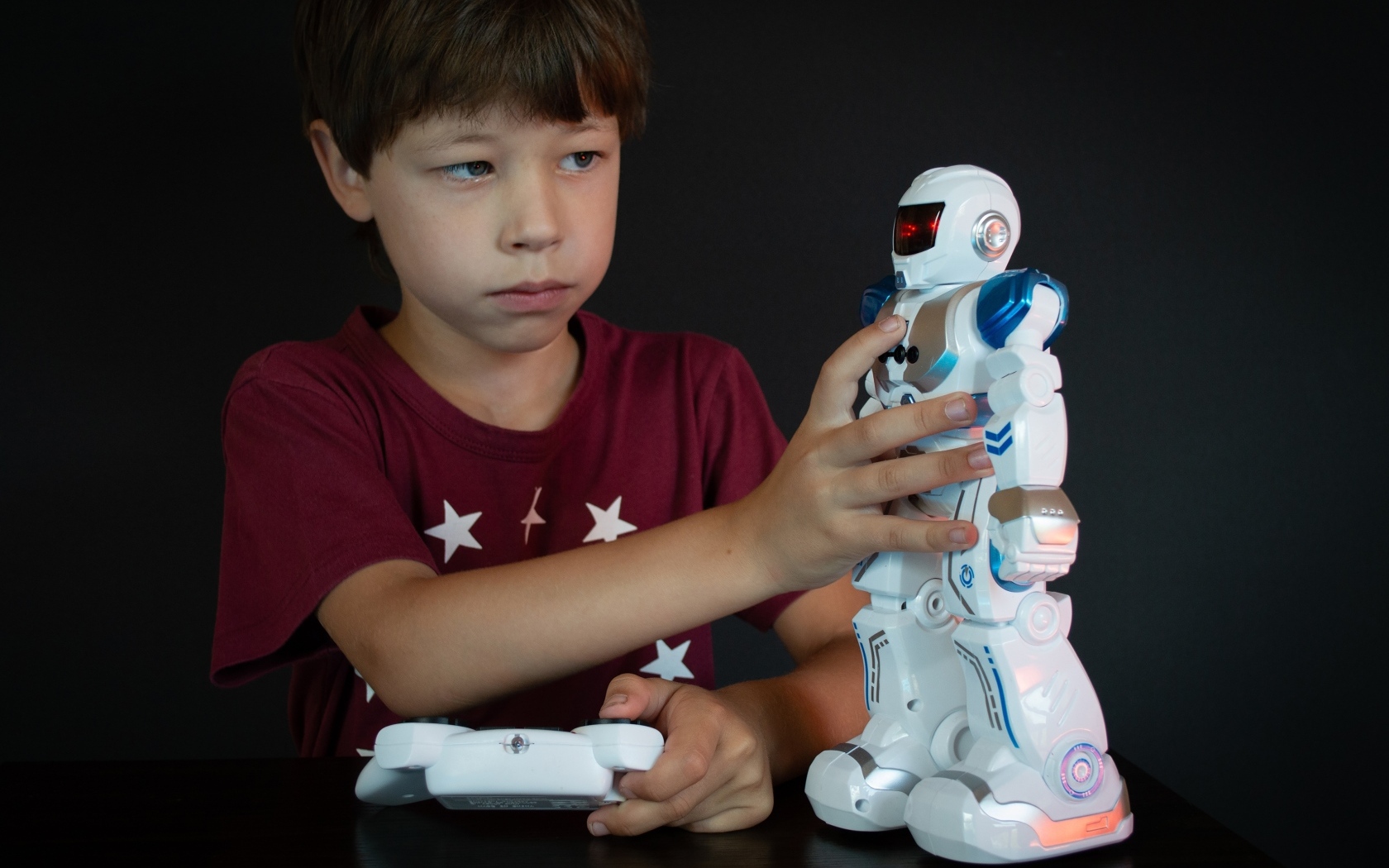 Маленький мальчик с роботом на черном фоне