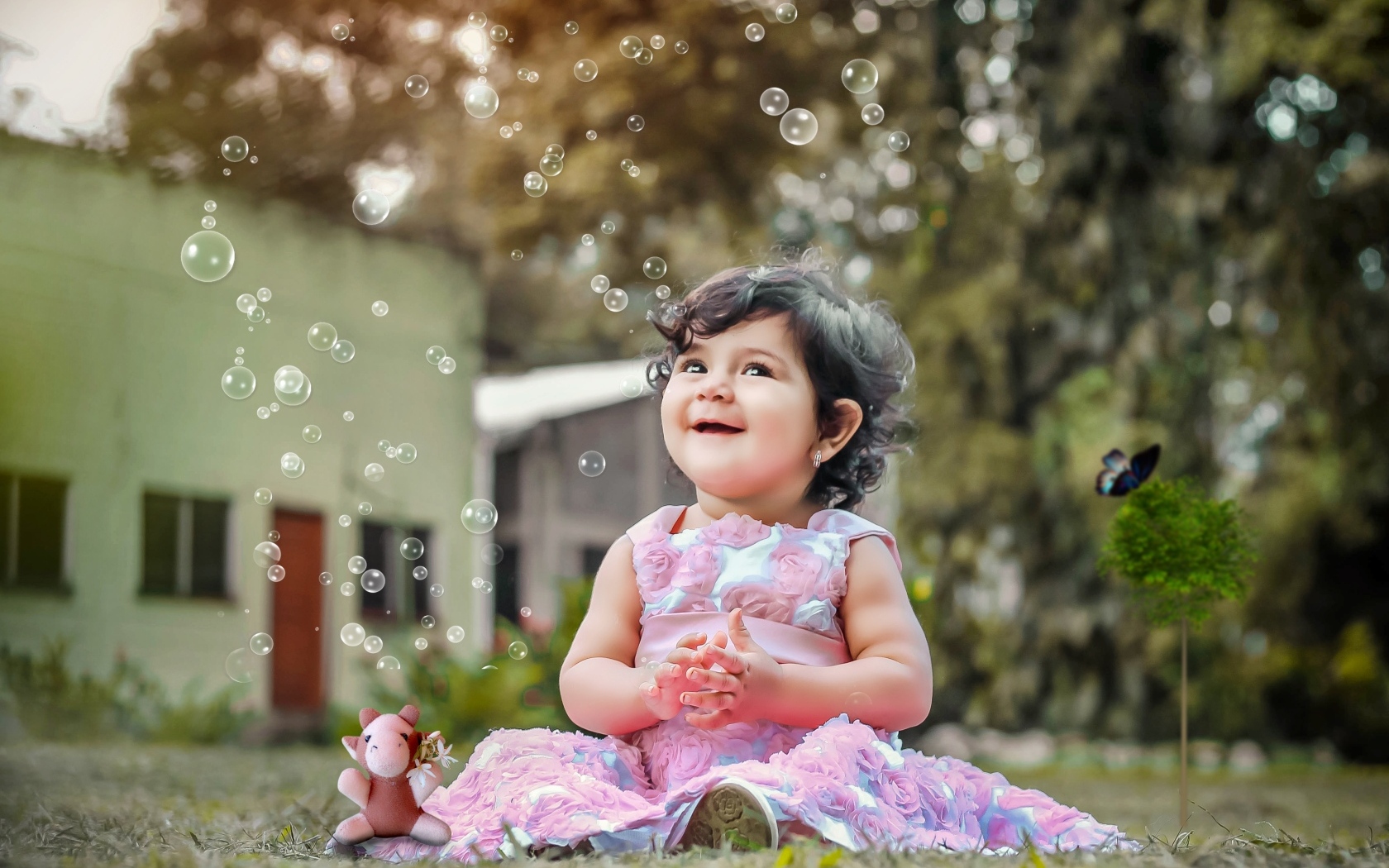 Маленькая девочка радуется мыльным пузырям
