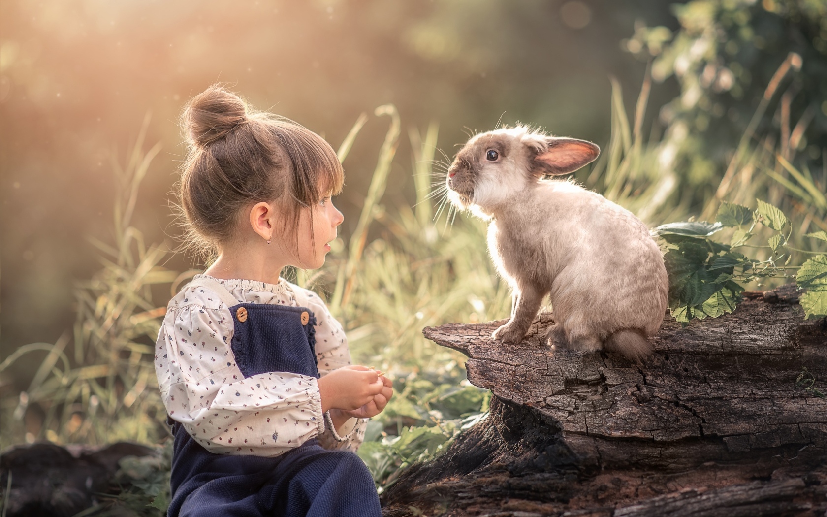 Маленькая девочка с кроликом в саду