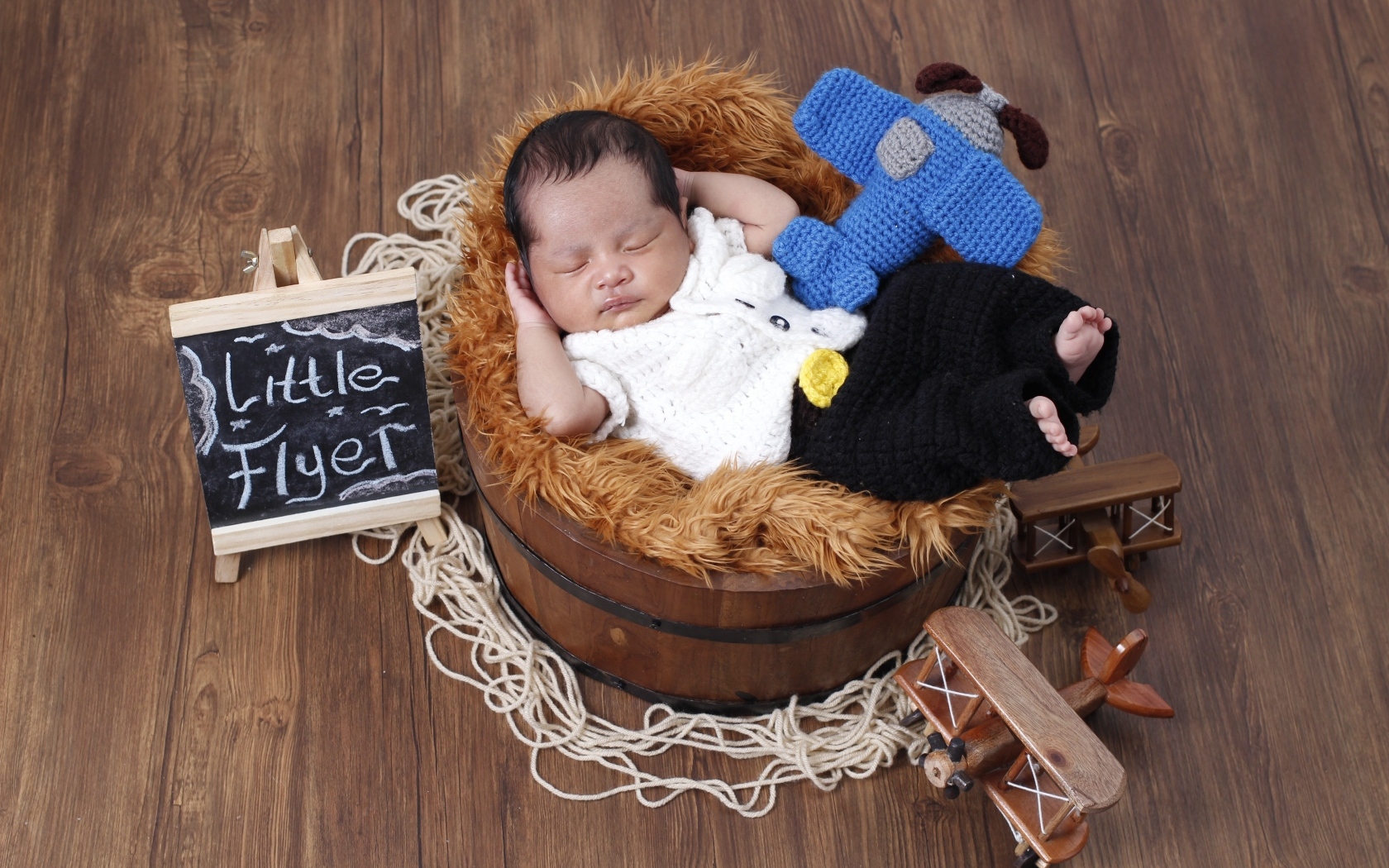 Маленький новорожденный малыш спит в бочке 