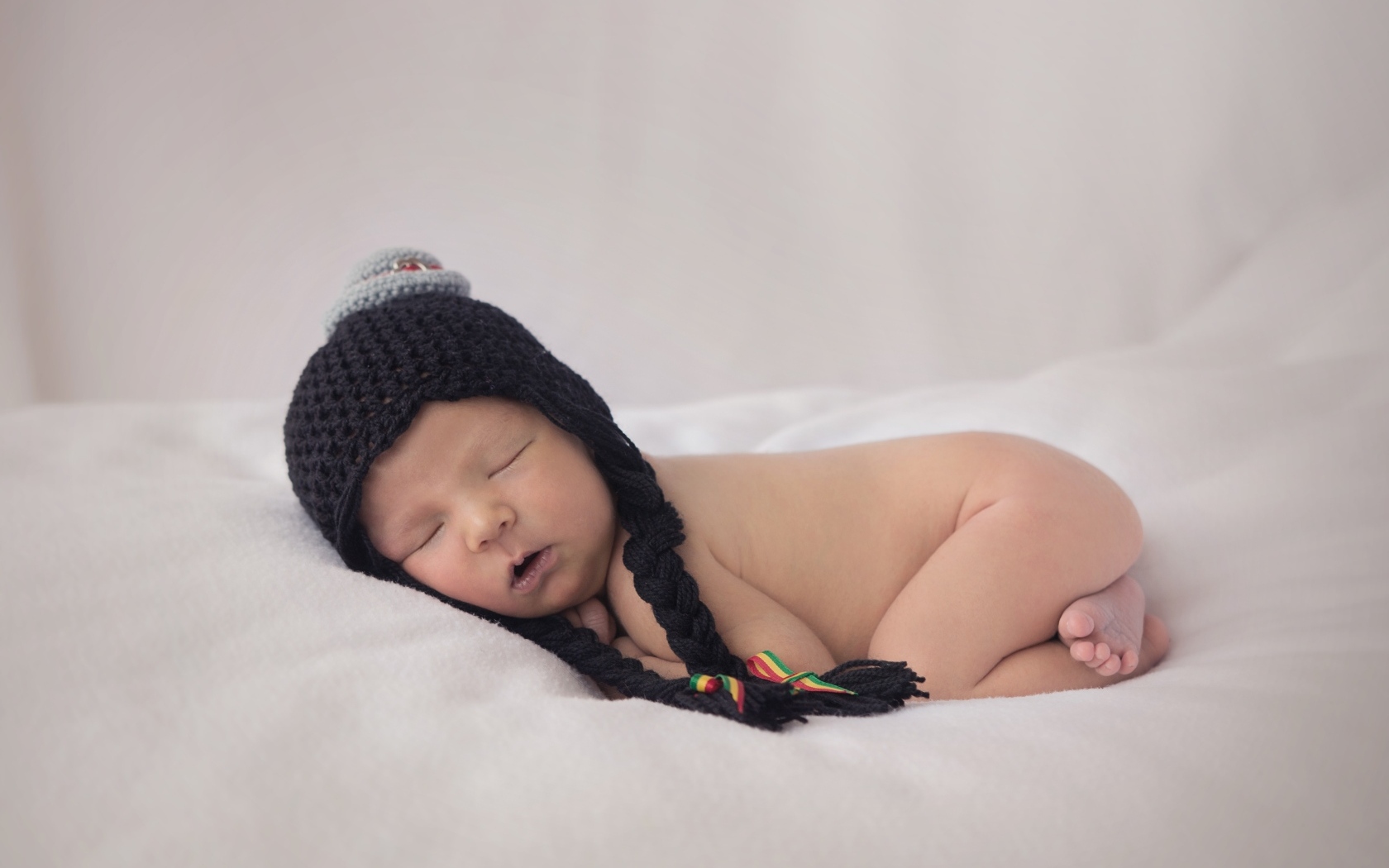 Новорожденная кроха в черной шапке