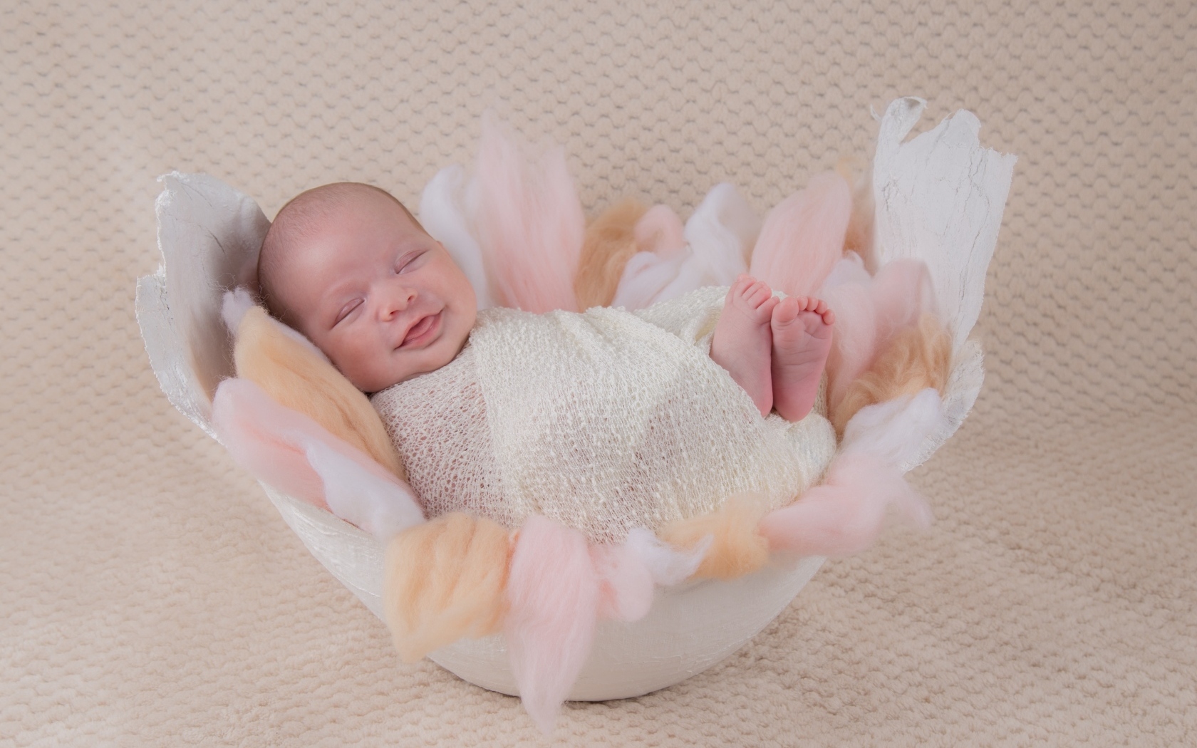 Улыбающийся спящий новорожденный малыш