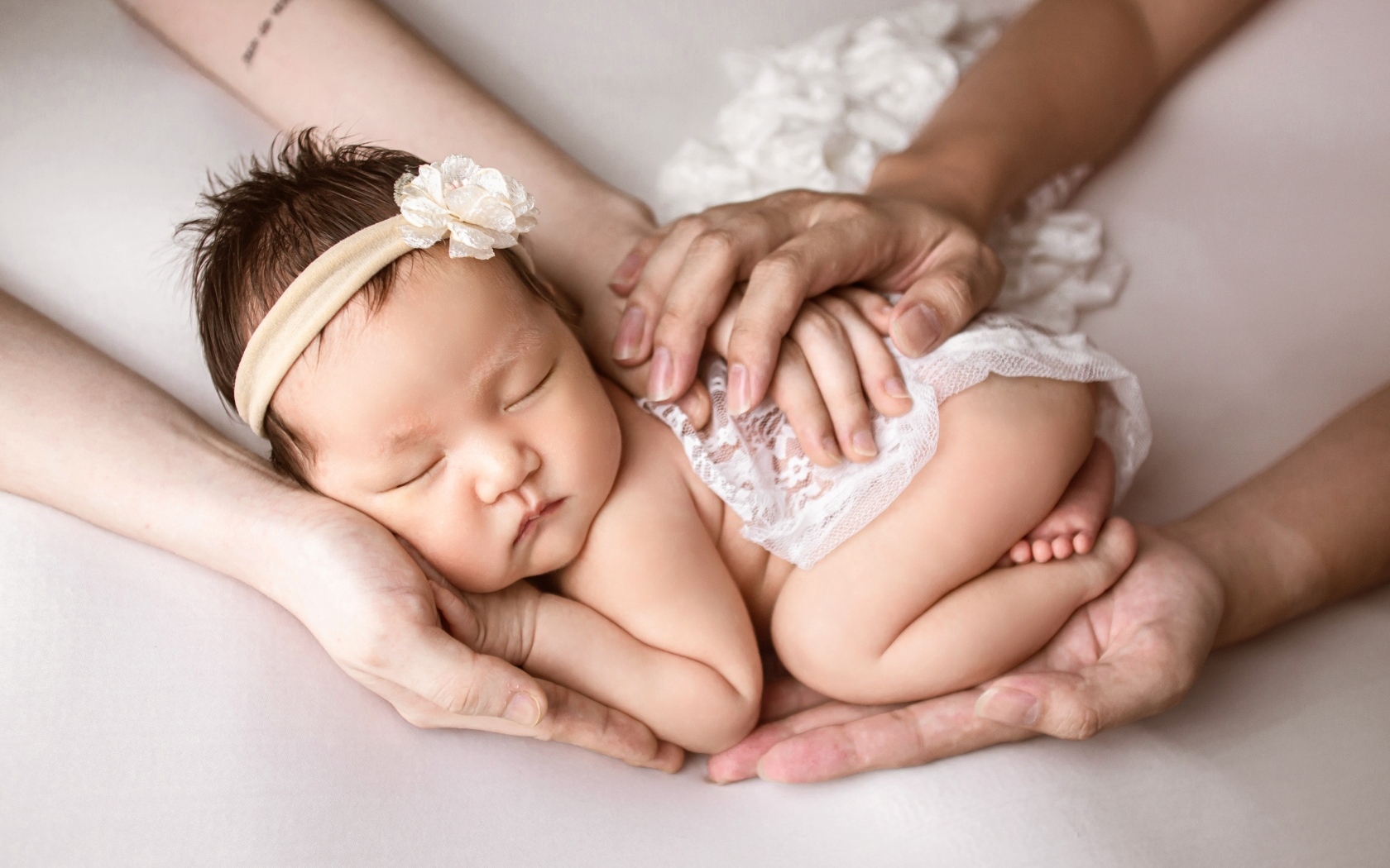 Руки родителей оберегают спящего малыша