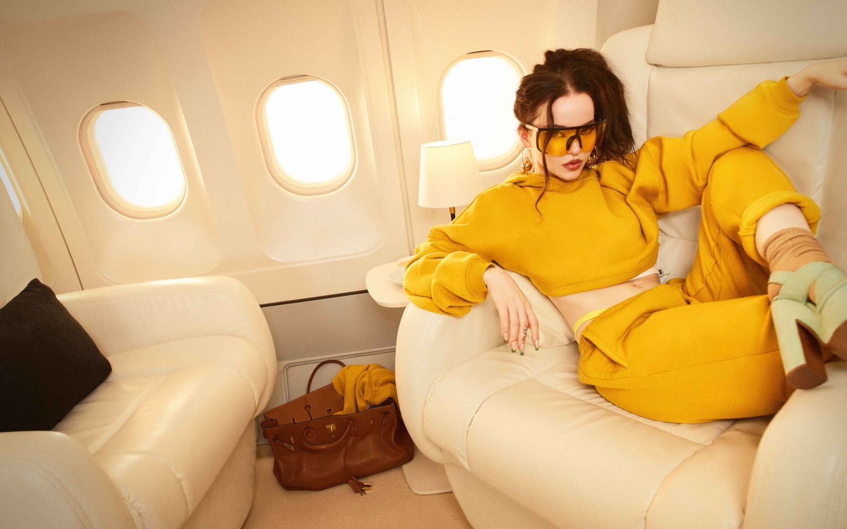 Актриса Дав Кэмерон в желтом костюме в самолете