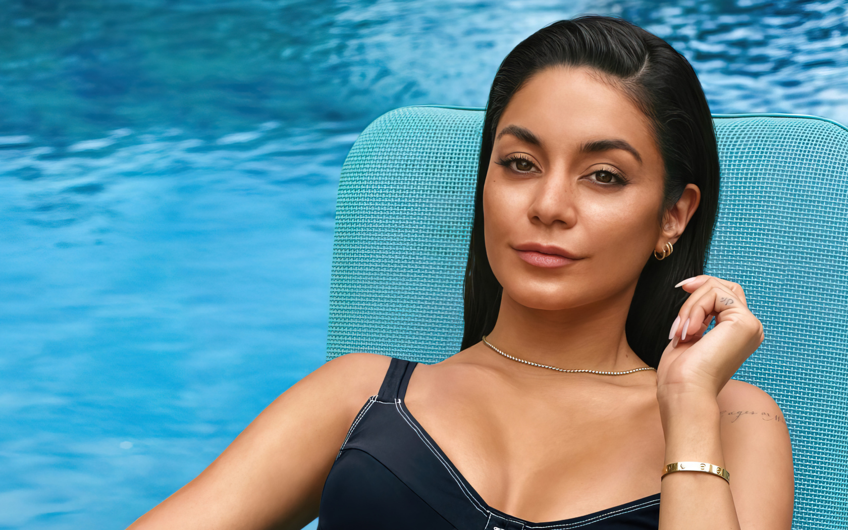 Актриса Ванесса Хадженс сидит у бассейна