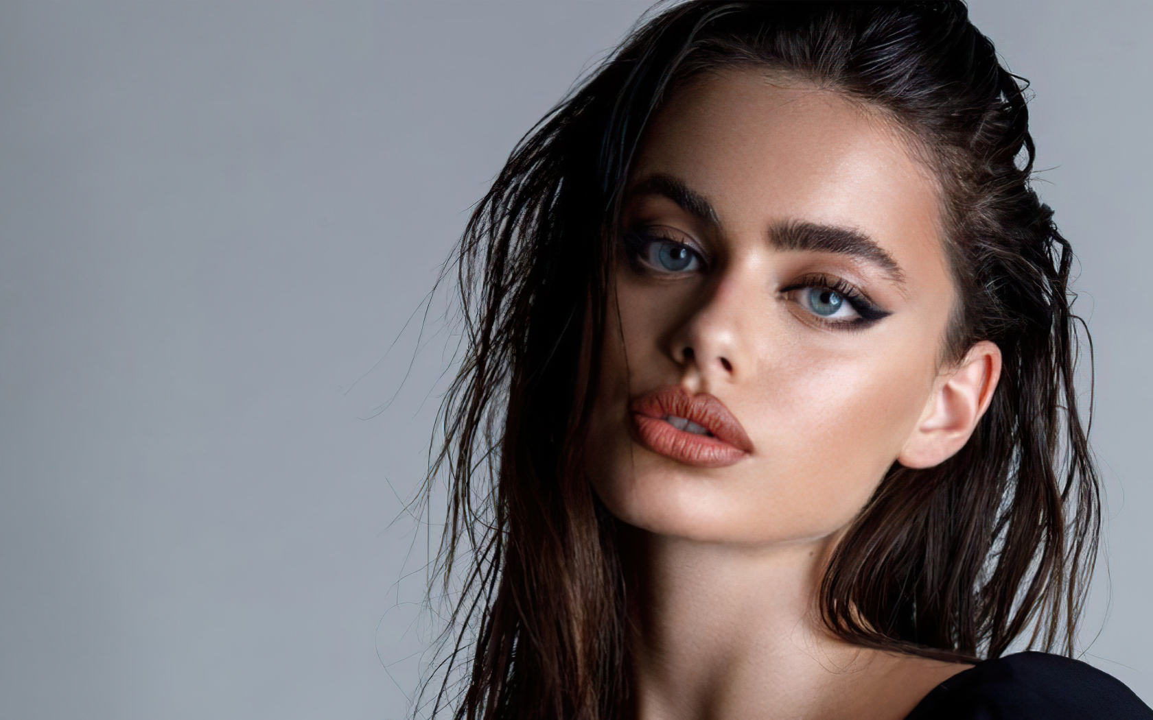 Красивая голубоглазая девушка Яэль Шелбиа на сером фоне